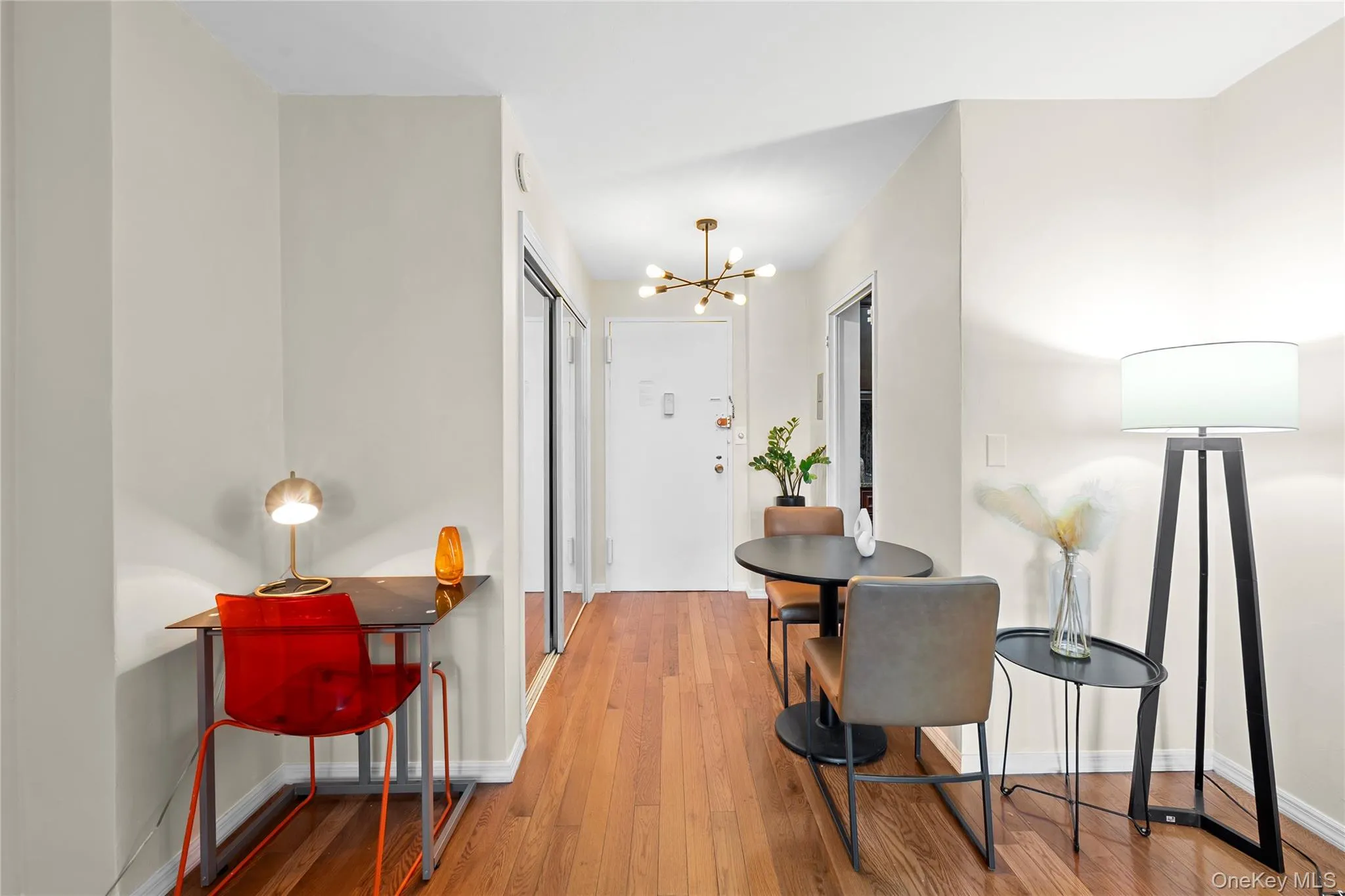 Wood-finish flooring throughout, light neutral wall paint, and a modern chandelier Wood-finish flooring throughout, light neutral wall paint, and a modern chandelier