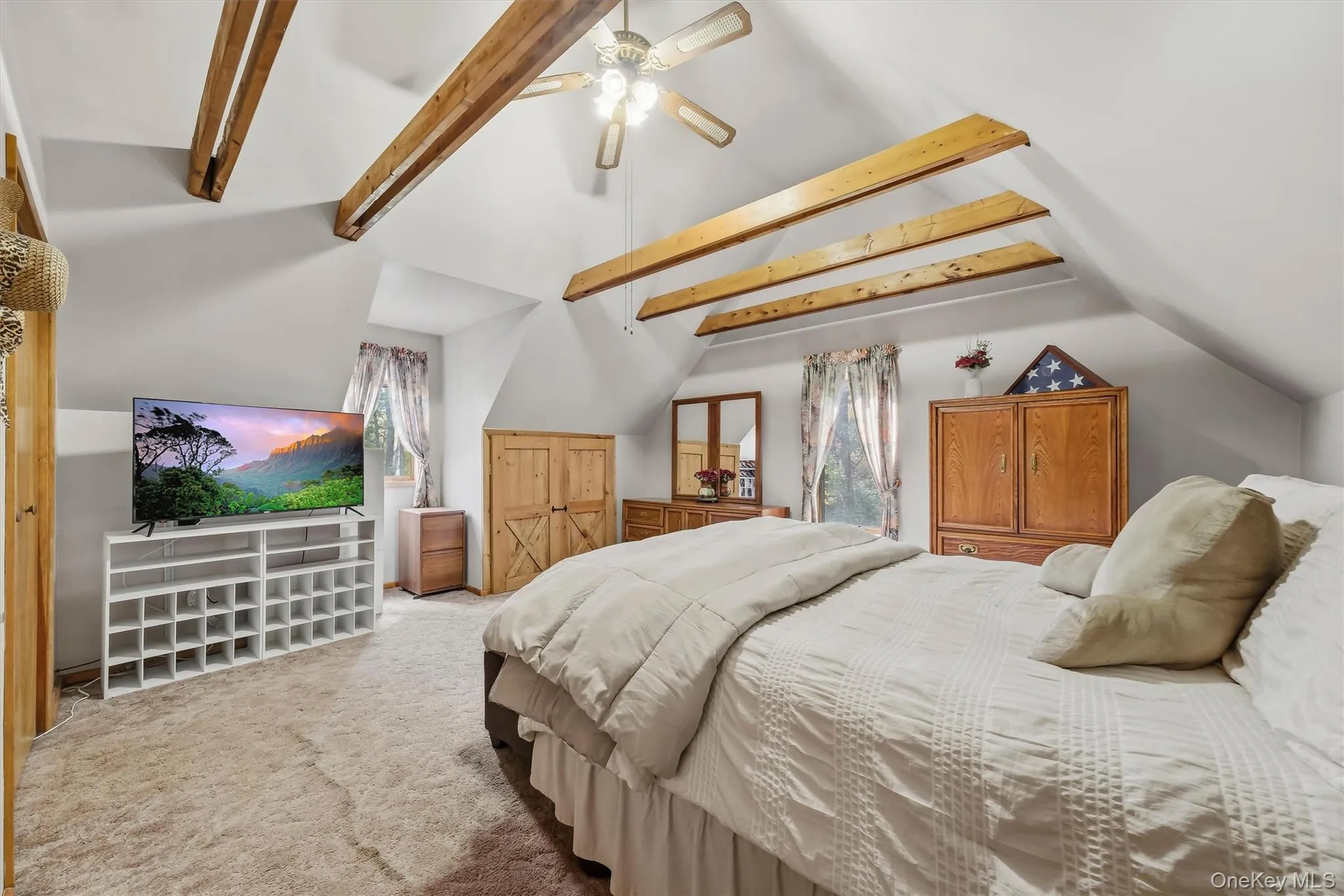 The primary bedroom is such an intimate space with vaulted ceilings, exposed beams and a knee wall closet with barn doors. The primary bedroom is such an intimate space with vaulted ceilings, exposed beams and a knee wall closet with barn doors.