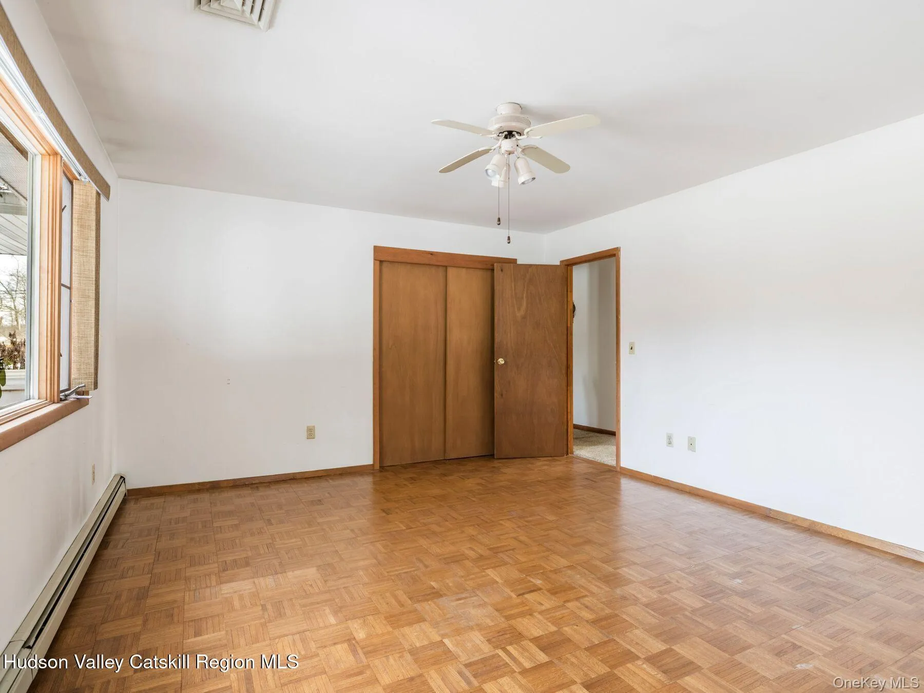 Parquet wood-finish flooring, white walls, wood-finish doors, and a ceiling fan Parquet wood-finish flooring, white walls, wood-finish doors, and a ceiling fan
