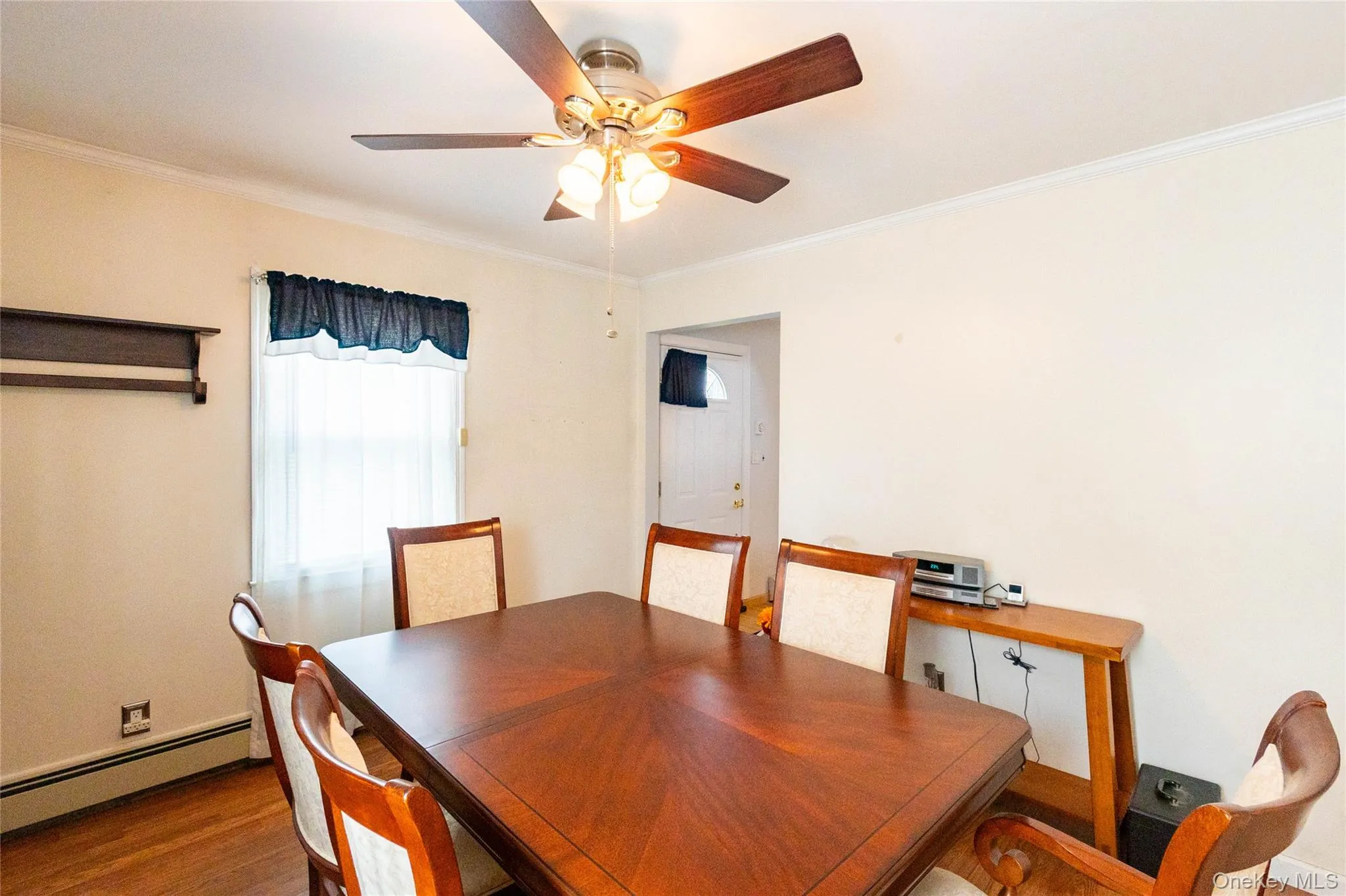 Ceiling fan with integrated lighting, wood-finish flooring, white trim, and a window for natural light Ceiling fan with integrated lighting, wood-finish flooring, white trim, and a window for natural light