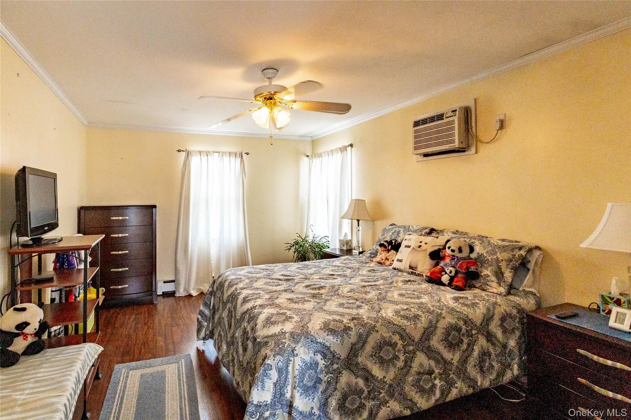 Crown molding detail, wood-finish flooring, ceiling fan, and wall-mounted air conditioning unit Crown molding detail, wood-finish flooring, ceiling fan, and wall-mounted air conditioning unit