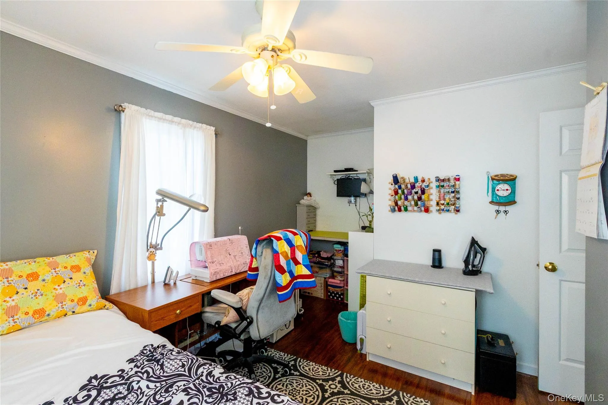 Hardwood-finish flooring, ceiling fan with integrated lighting, crown molding, and a built-in desk area Hardwood-finish flooring, ceiling fan with integrated lighting, crown molding, and a built-in desk area