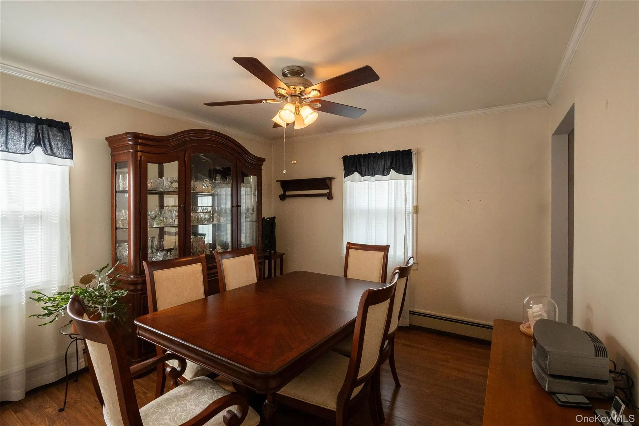 Wood-finish flooring, crown molding, ceiling fan, and window with blinds Wood-finish flooring, crown molding, ceiling fan, and window with blinds
