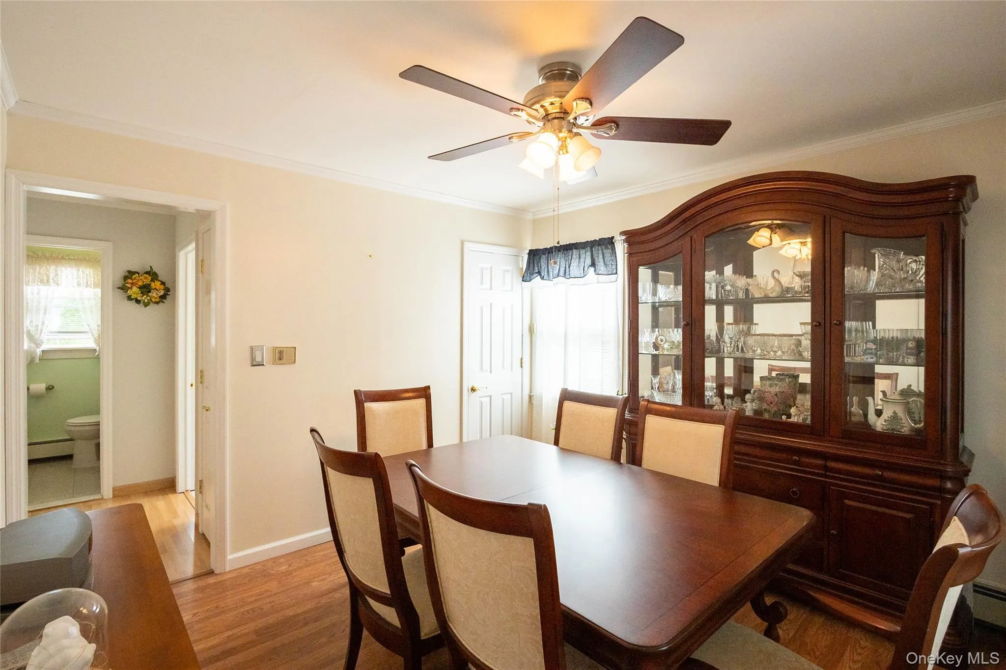 Hardwood flooring throughout, crown molding, and a ceiling fan with integrated lighting Hardwood flooring throughout, crown molding, and a ceiling fan with integrated lighting