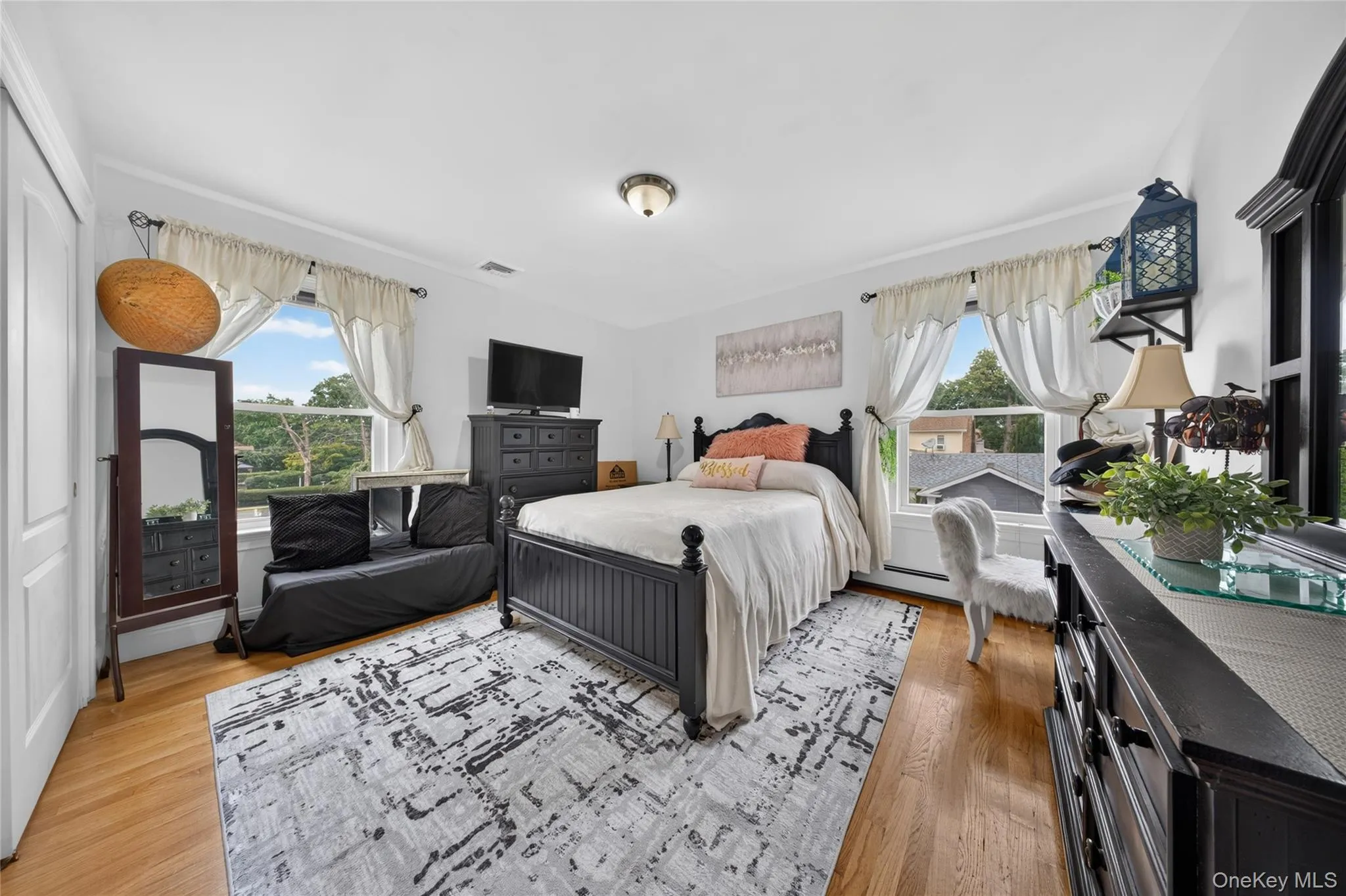 Hardwood flooring, multiple windows, overhead lighting, and white walls Hardwood flooring, multiple windows, overhead lighting, and white walls