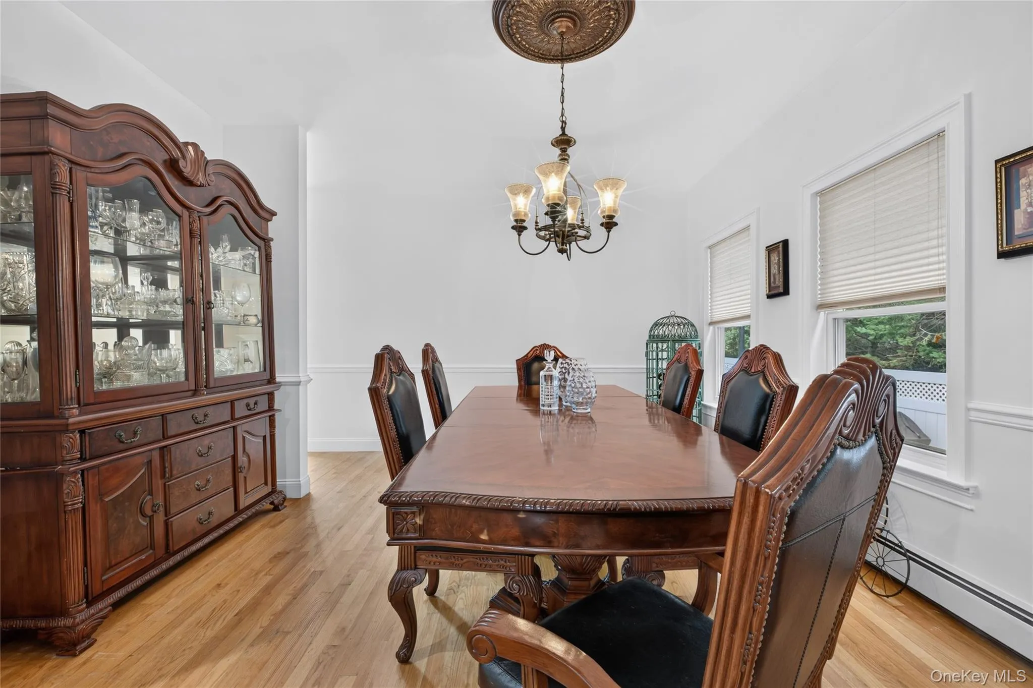 Hardwood flooring, crown molding, white trim, and a decorative ceiling medallion with a chandelier Hardwood flooring, crown molding, white trim, and a decorative ceiling medallion with a chandelier