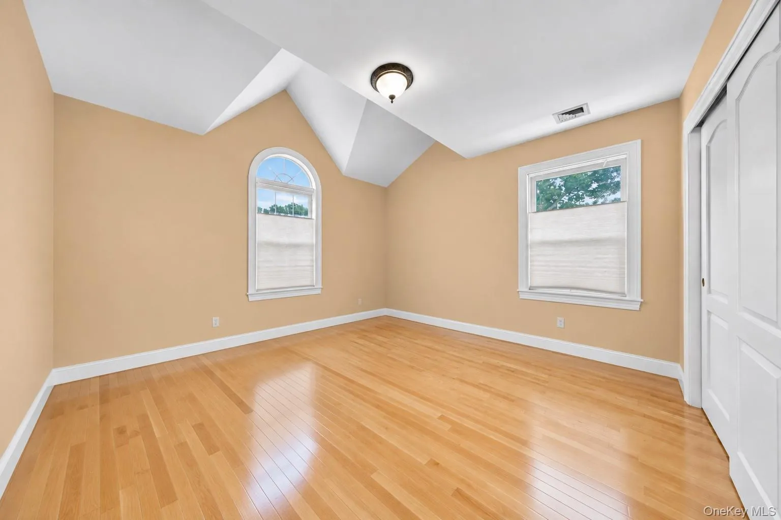Hardwood flooring throughout, arched window, vaulted ceiling, recessed lighting, and white trim Hardwood flooring throughout, arched window, vaulted ceiling, recessed lighting, and white trim