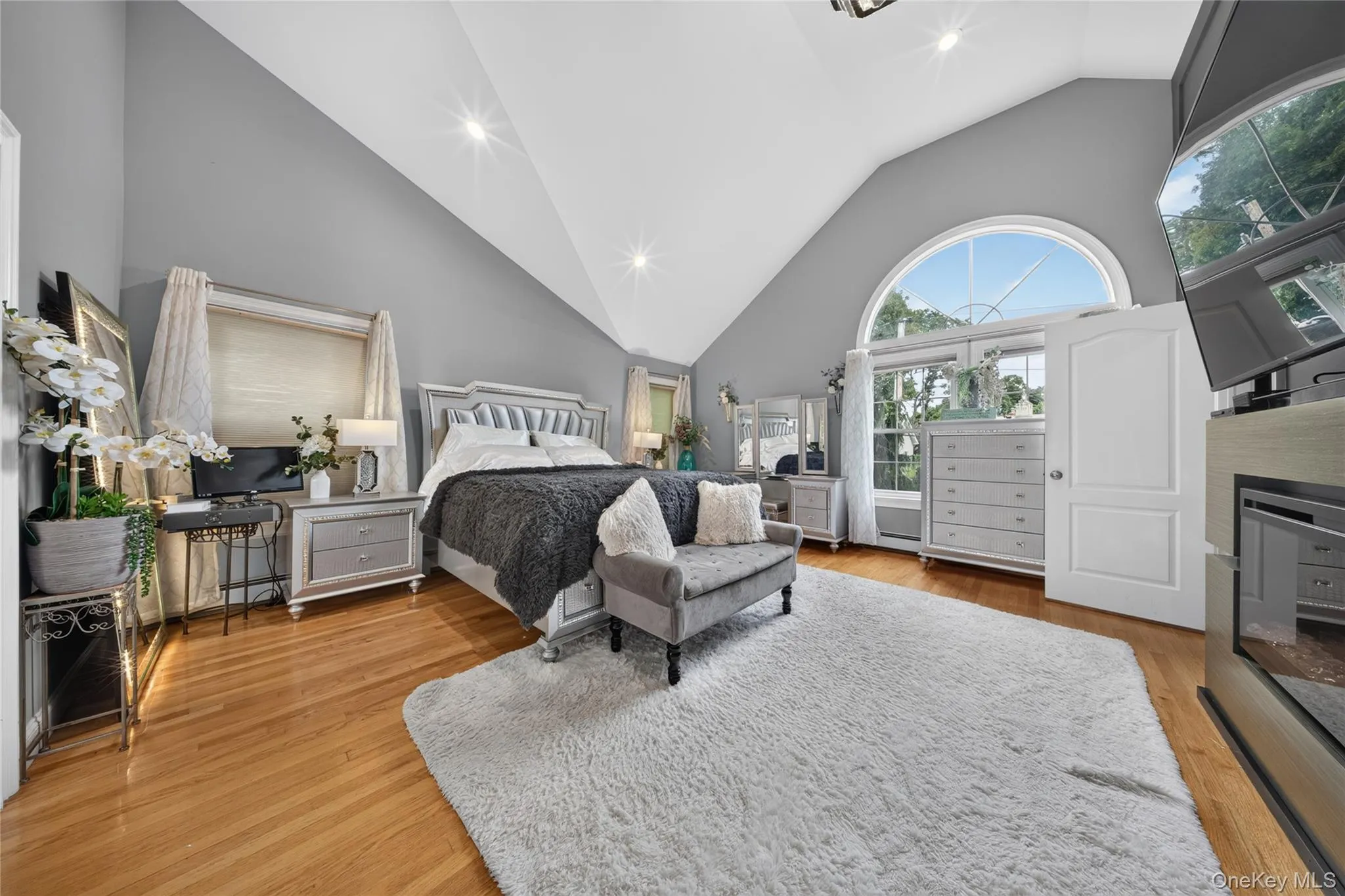 Hardwood flooring, vaulted ceiling, arched window, and recessed lighting Hardwood flooring, vaulted ceiling, arched window, and recessed lighting