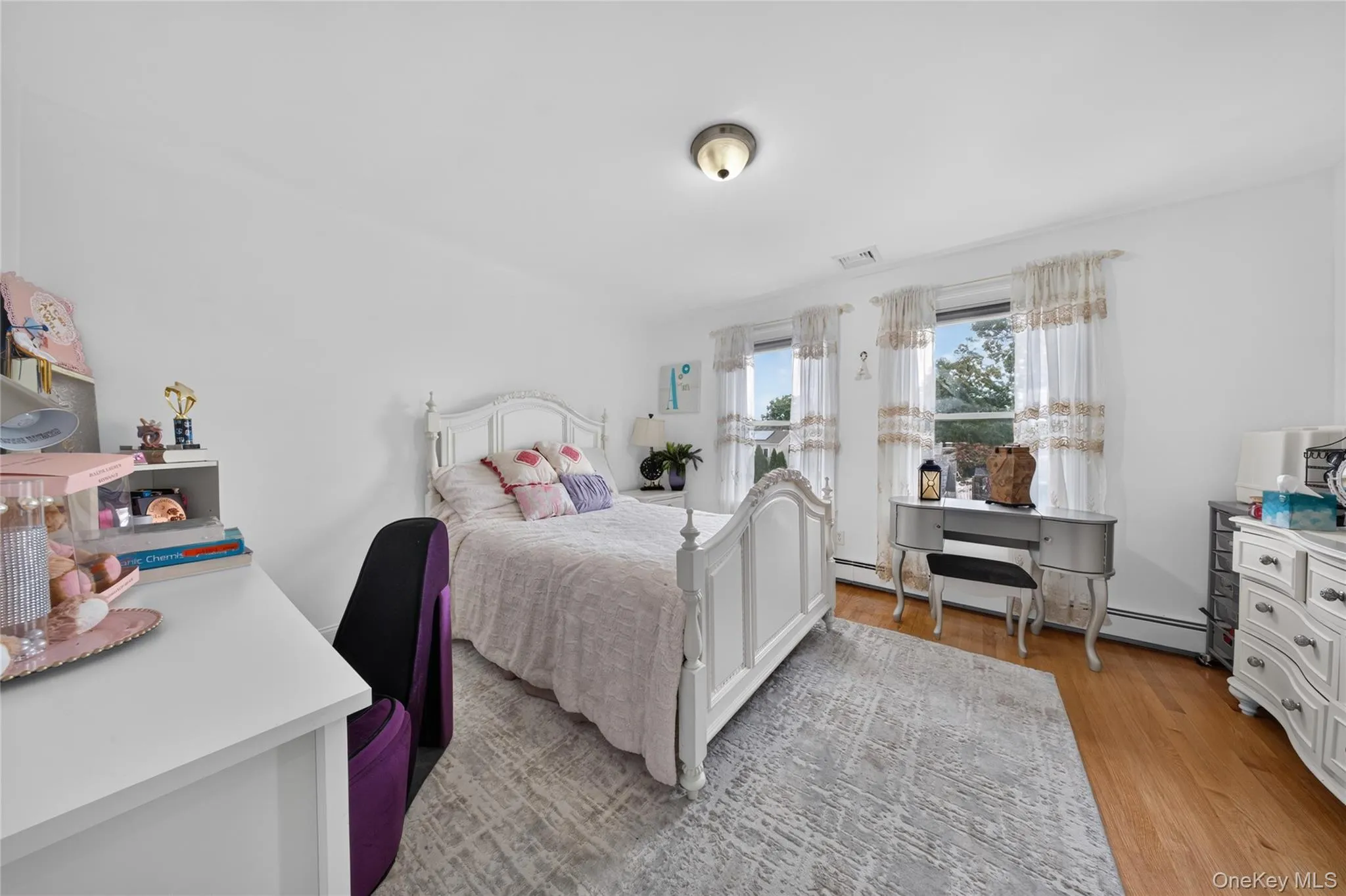 Hardwood-finish flooring, two window exposures, ceiling-mounted light fixture, white painted walls, and white trim Hardwood-finish flooring, two window exposures, ceiling-mounted light fixture, white painted walls, and white trim