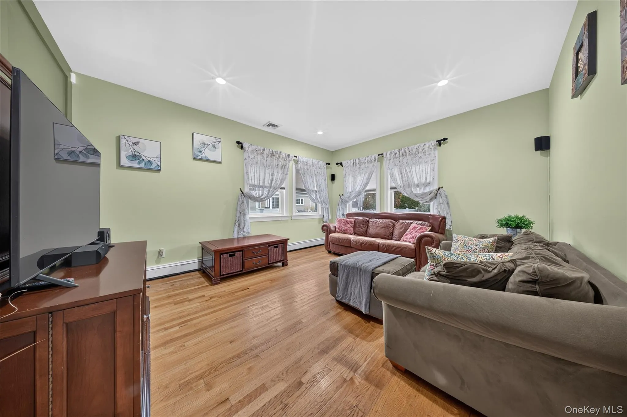 Hardwood flooring, recessed ceiling lighting, light-toned wall paint, and multiple windows Hardwood flooring, recessed ceiling lighting, light-toned wall paint, and multiple windows