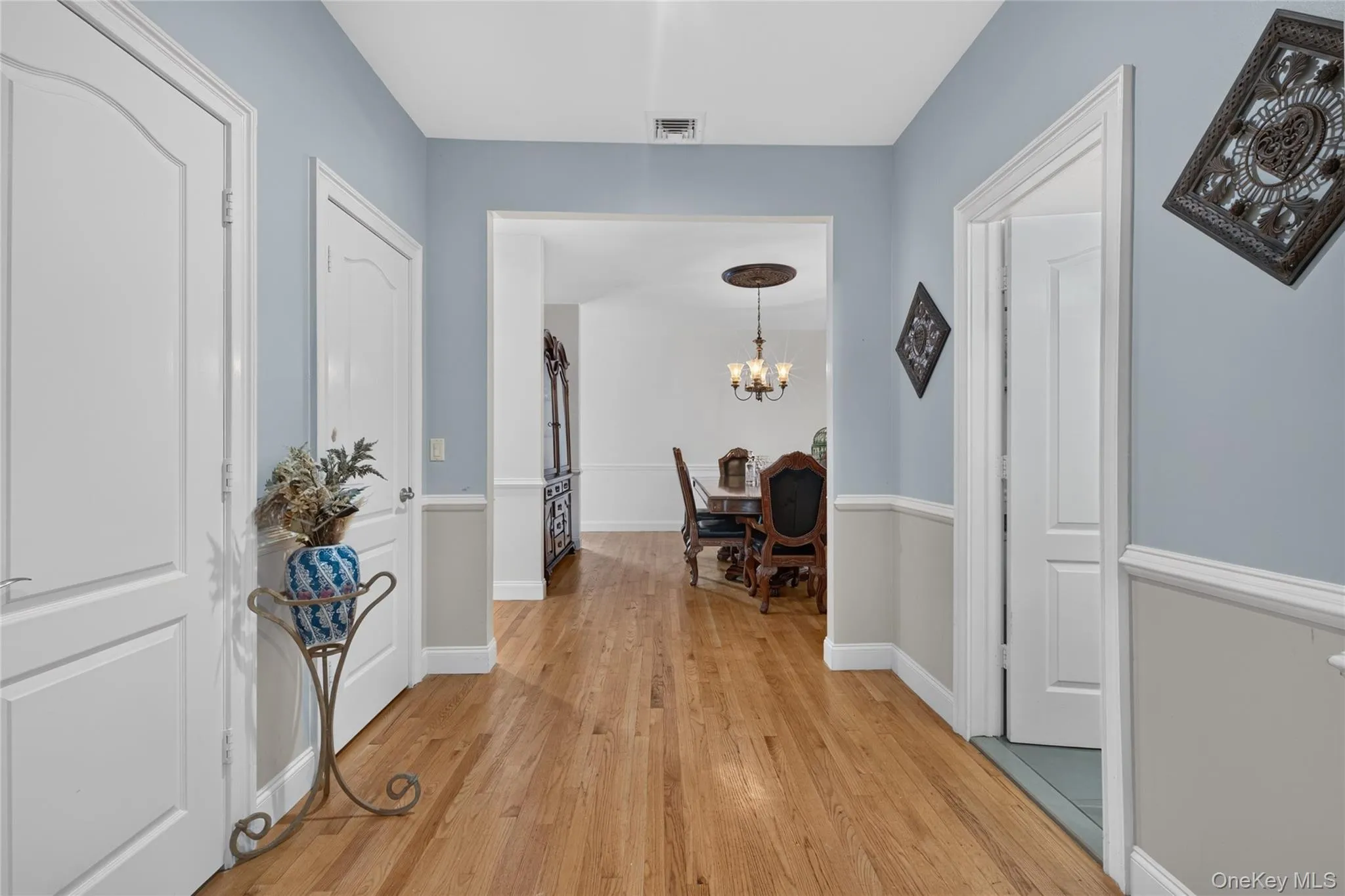 Hardwood flooring, crown molding, white paneled doors, and wainscoting Hardwood flooring, crown molding, white paneled doors, and wainscoting
