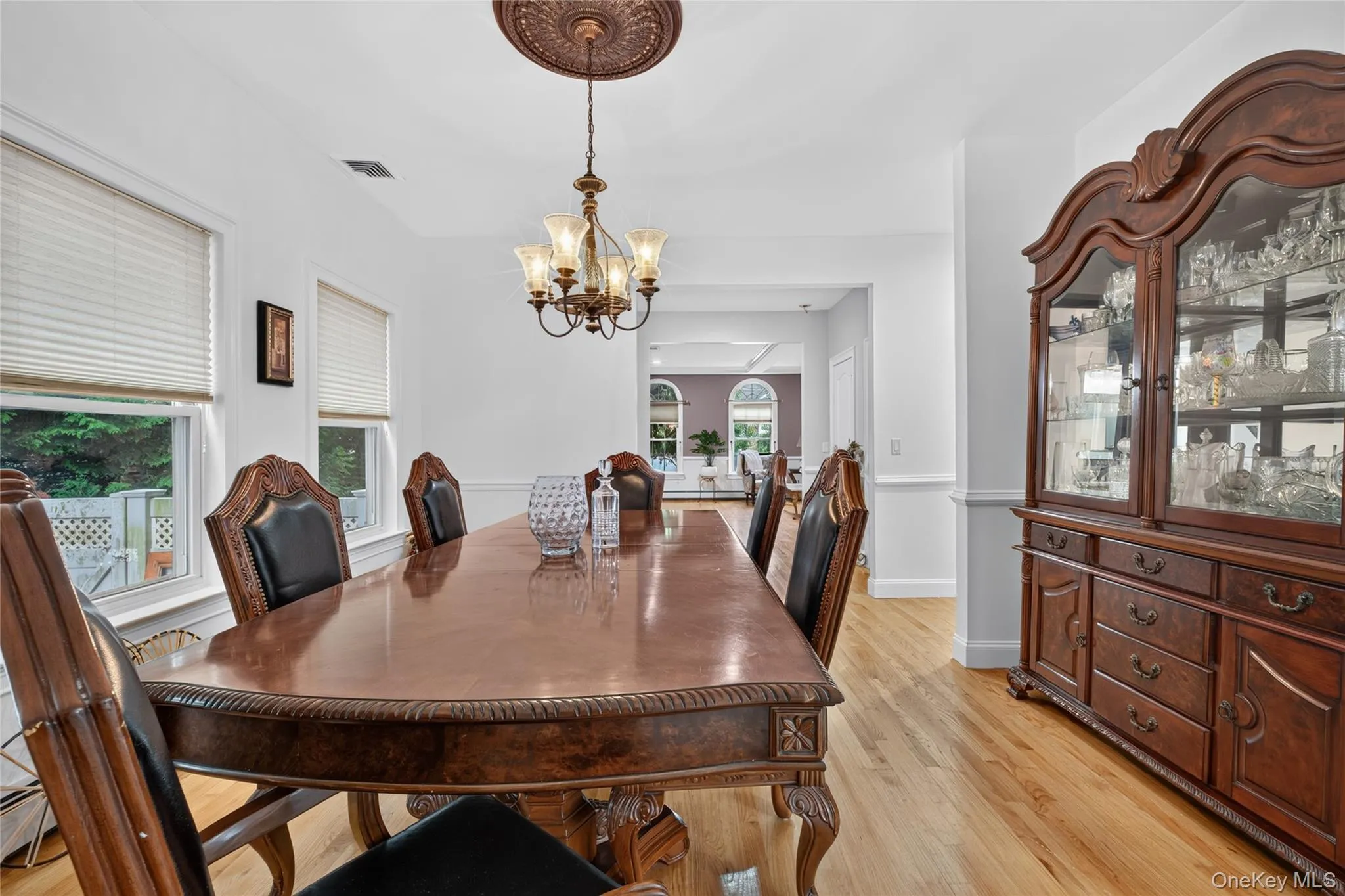 Hardwood flooring, chandelier with decorative ceiling medallion, white painted walls, and window treatments Hardwood flooring, chandelier with decorative ceiling medallion, white painted walls, and window treatments