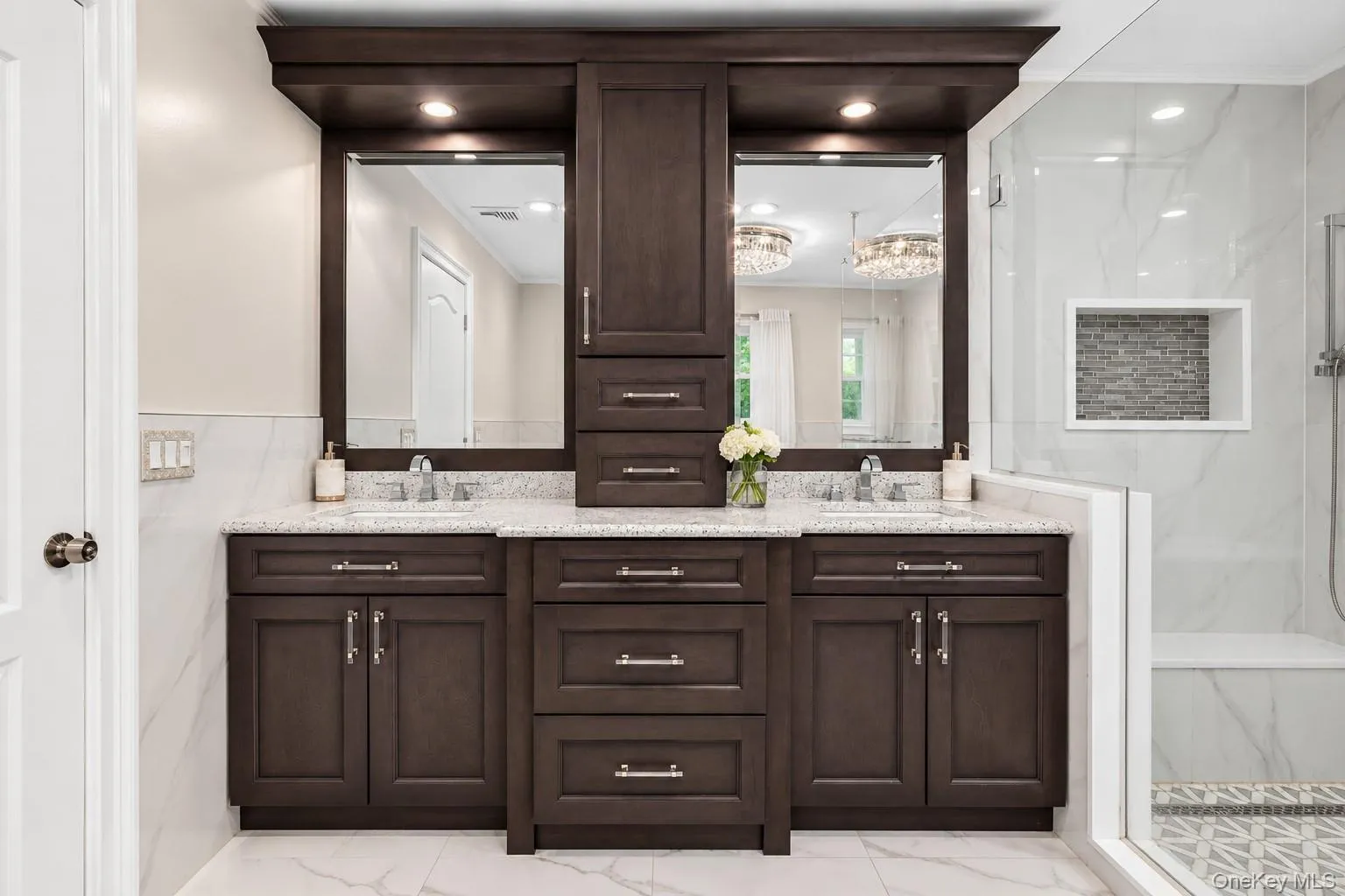 Double vanity with dark wood-finish cabinetry, white countertops, and undermount sinks Double vanity with dark wood-finish cabinetry, white countertops, and undermount sinks