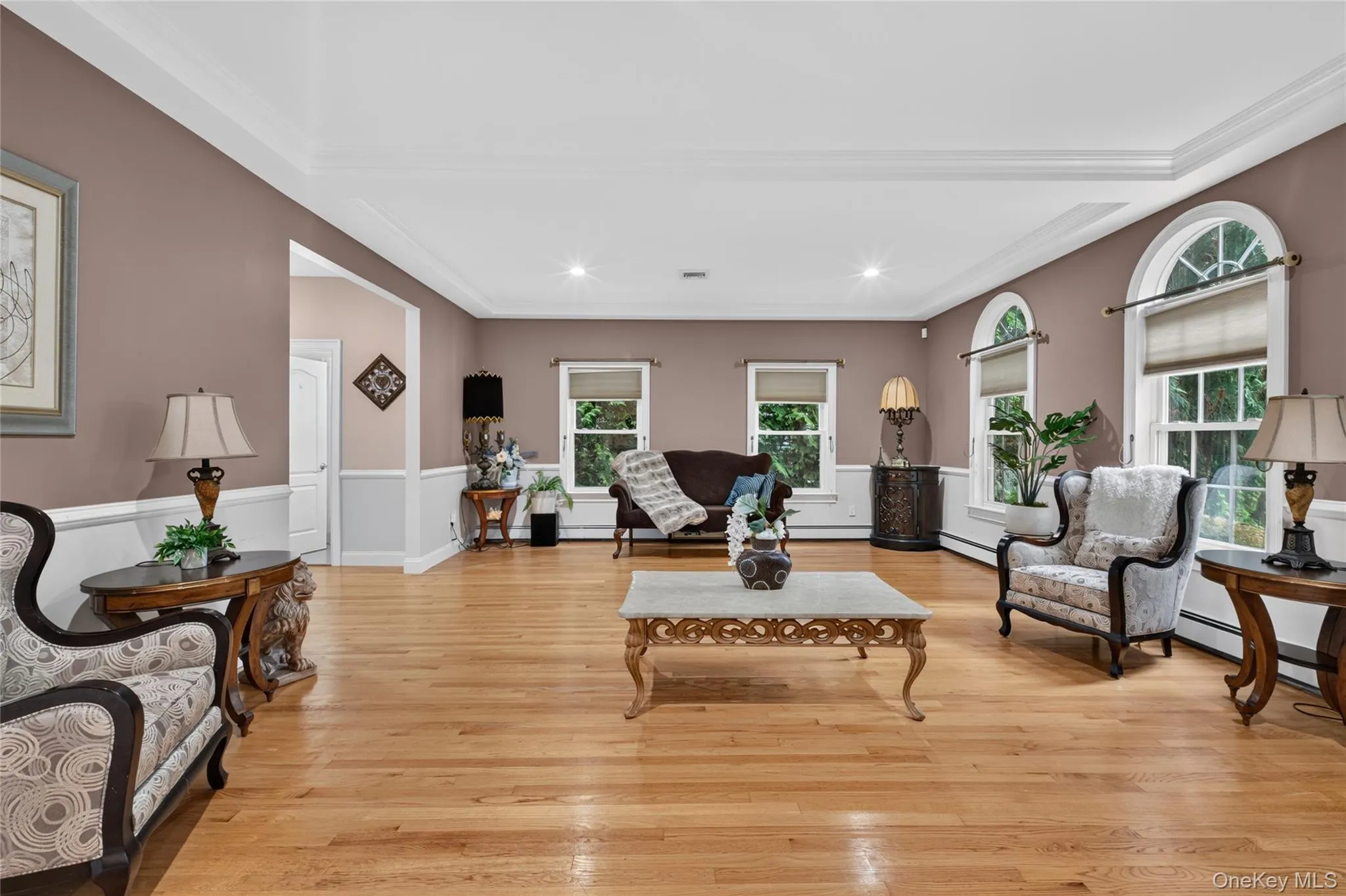 Hardwood flooring, crown molding, recessed lighting, wainscoting, and arched windows Hardwood flooring, crown molding, recessed lighting, wainscoting, and arched windows