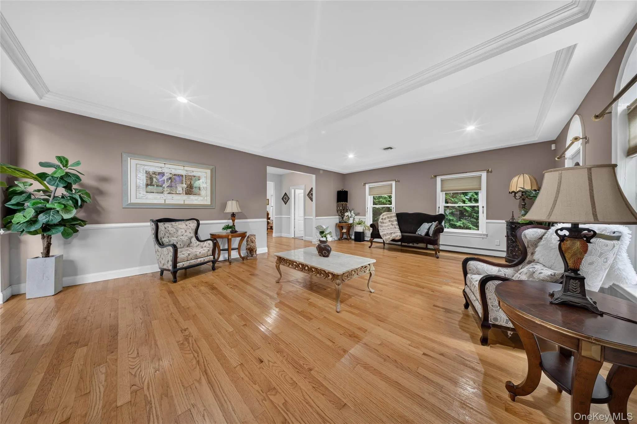 Hardwood flooring, tray ceiling, recessed lighting, and wall paneling Hardwood flooring, tray ceiling, recessed lighting, and wall paneling