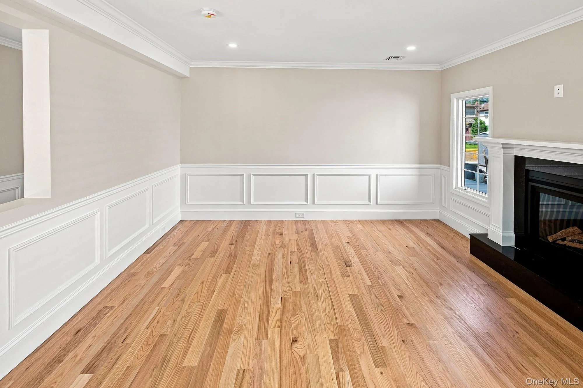 Family Room - hardwood flooring, crown molding, wainscoting, recessed lighting, and fireplace with a mantel. Family Room - hardwood flooring, crown molding, wainscoting, recessed lighting, and fireplace with a mantel.