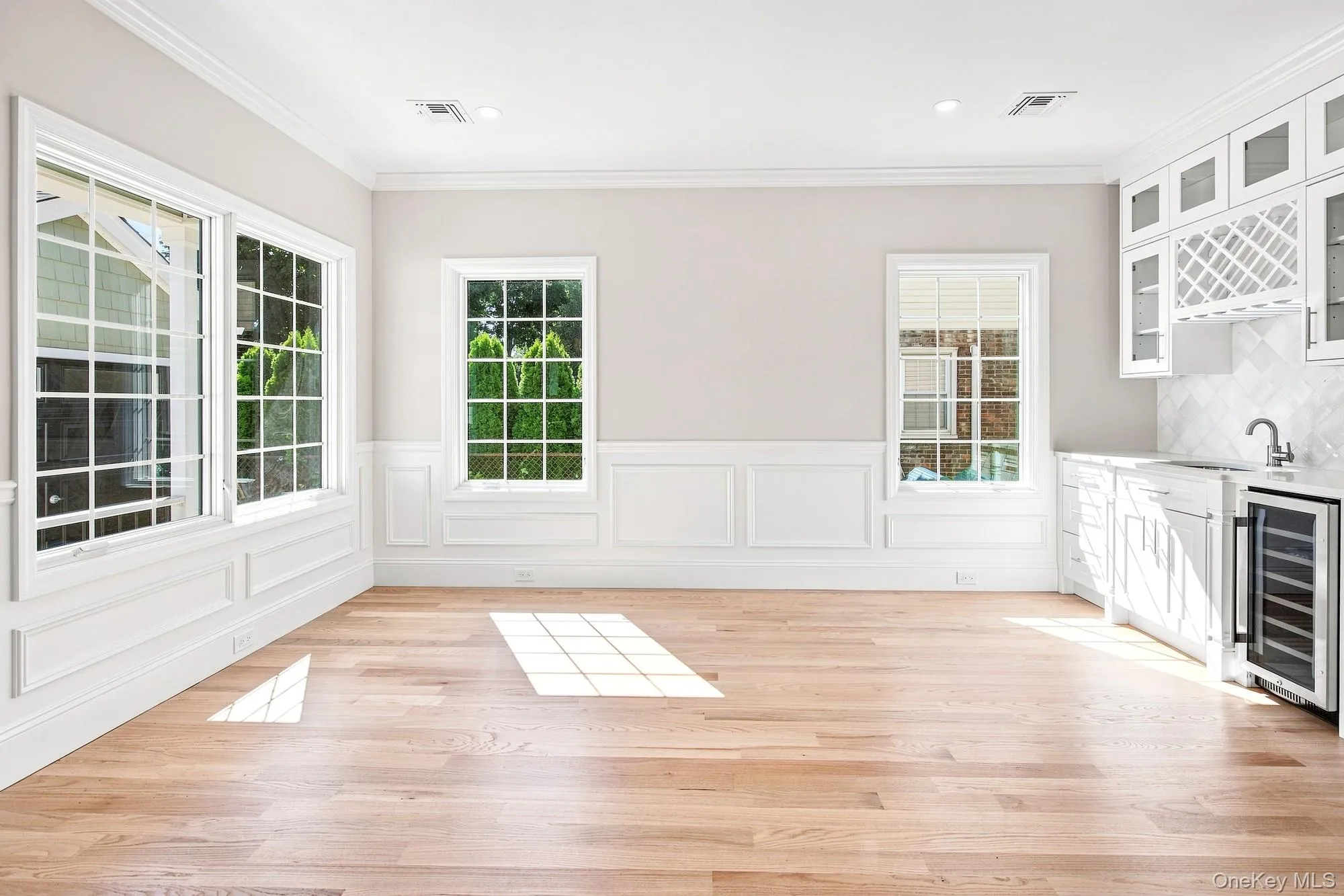 Dining Room - light wood-finish flooring, multiple paneled windows, recessed lighting, built-in cabinetry with glass inserts, and a beverage cooler. Dining Room - light wood-finish flooring, multiple paneled windows, recessed lighting, built-in cabinetry with glass inserts, and a beverage cooler.