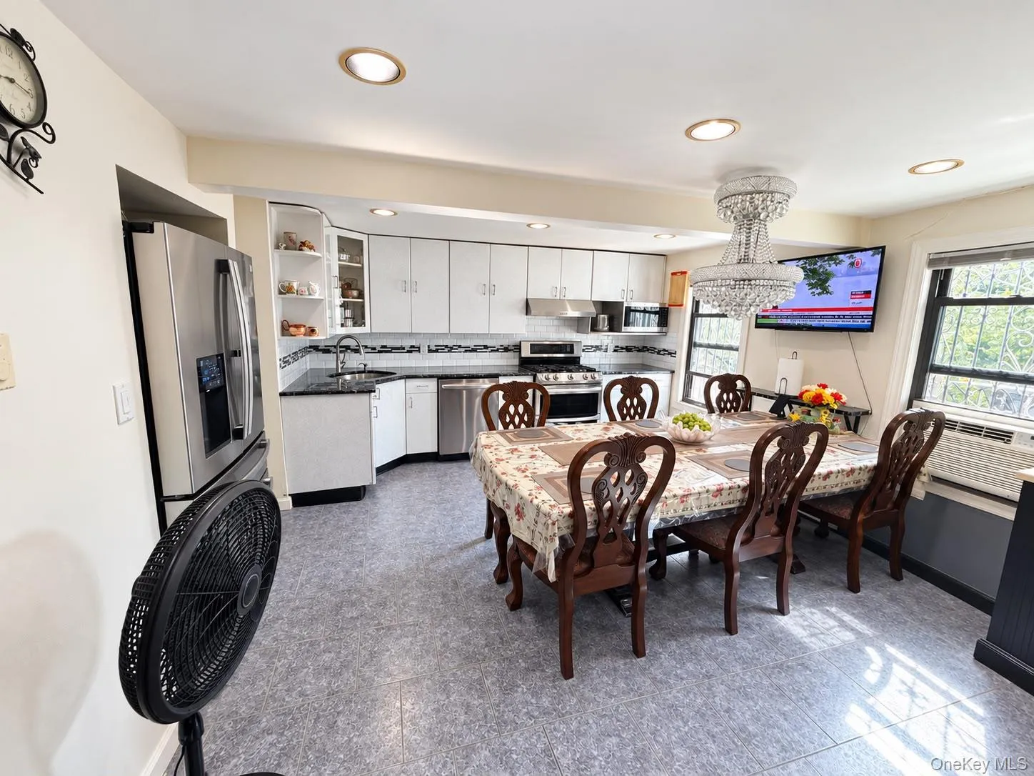 Kitchen featuring recessed lighting, stainless steel appliances, white cabinetry, dark speckled countertops, and a tile backsplash Kitchen featuring recessed lighting, stainless steel appliances, white cabinetry, dark speckled countertops, and a tile backsplash