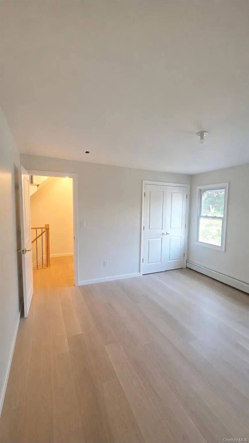 Light wood-finish flooring, white walls, double-door closet, single window, and a white ceiling Light wood-finish flooring, white walls, double-door closet, single window, and a white ceiling