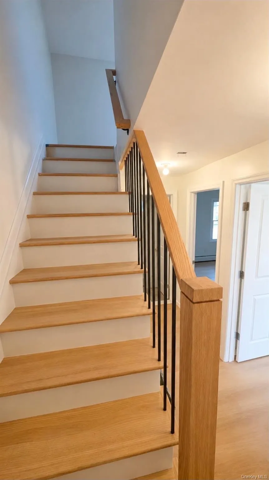 Hardwood staircase with painted risers and a wood newel post Hardwood staircase with painted risers and a wood newel post