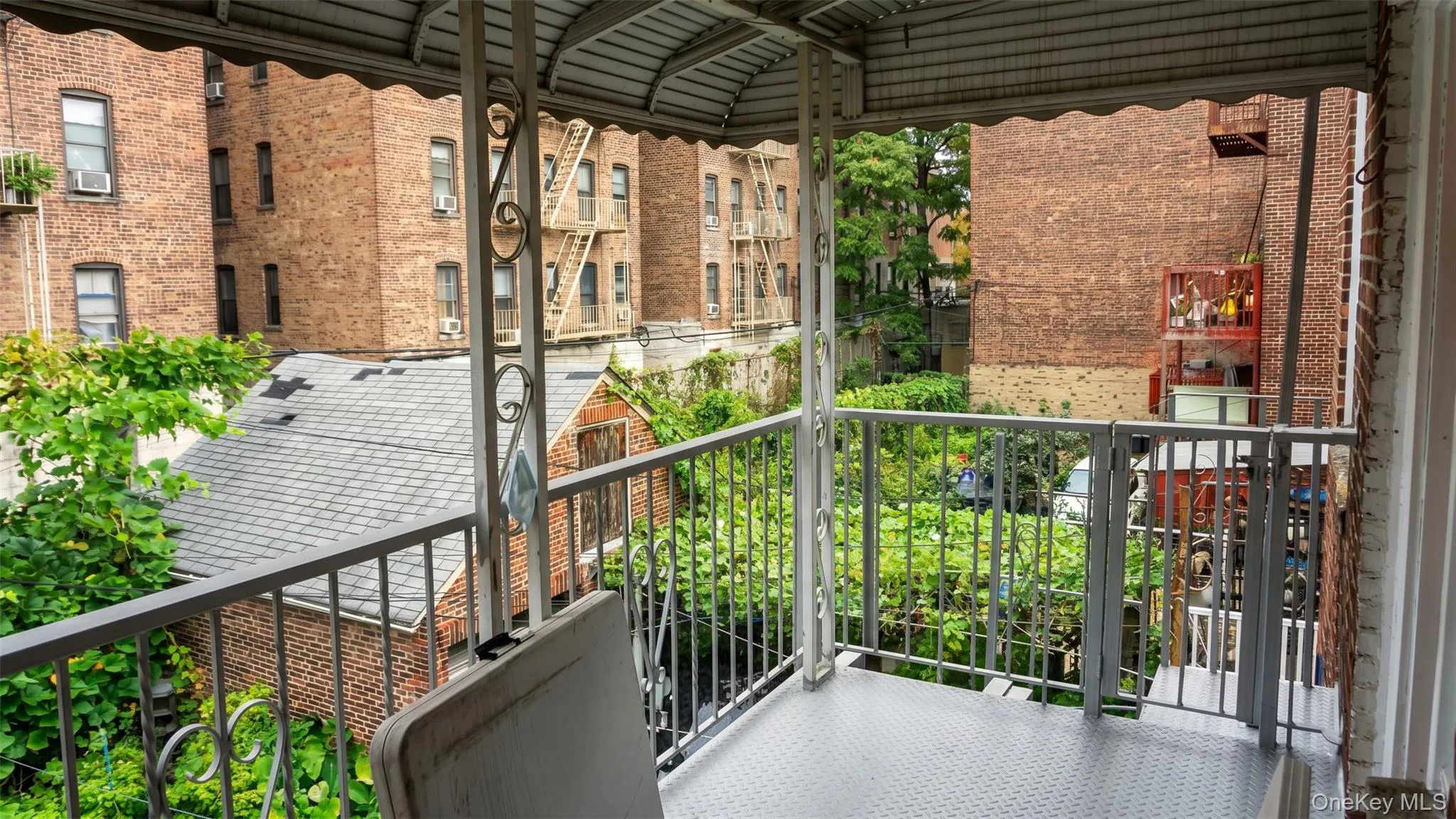 Balcony with metal railing, diamond plate flooring, and a corrugated metal awning Balcony with metal railing, diamond plate flooring, and a corrugated metal awning