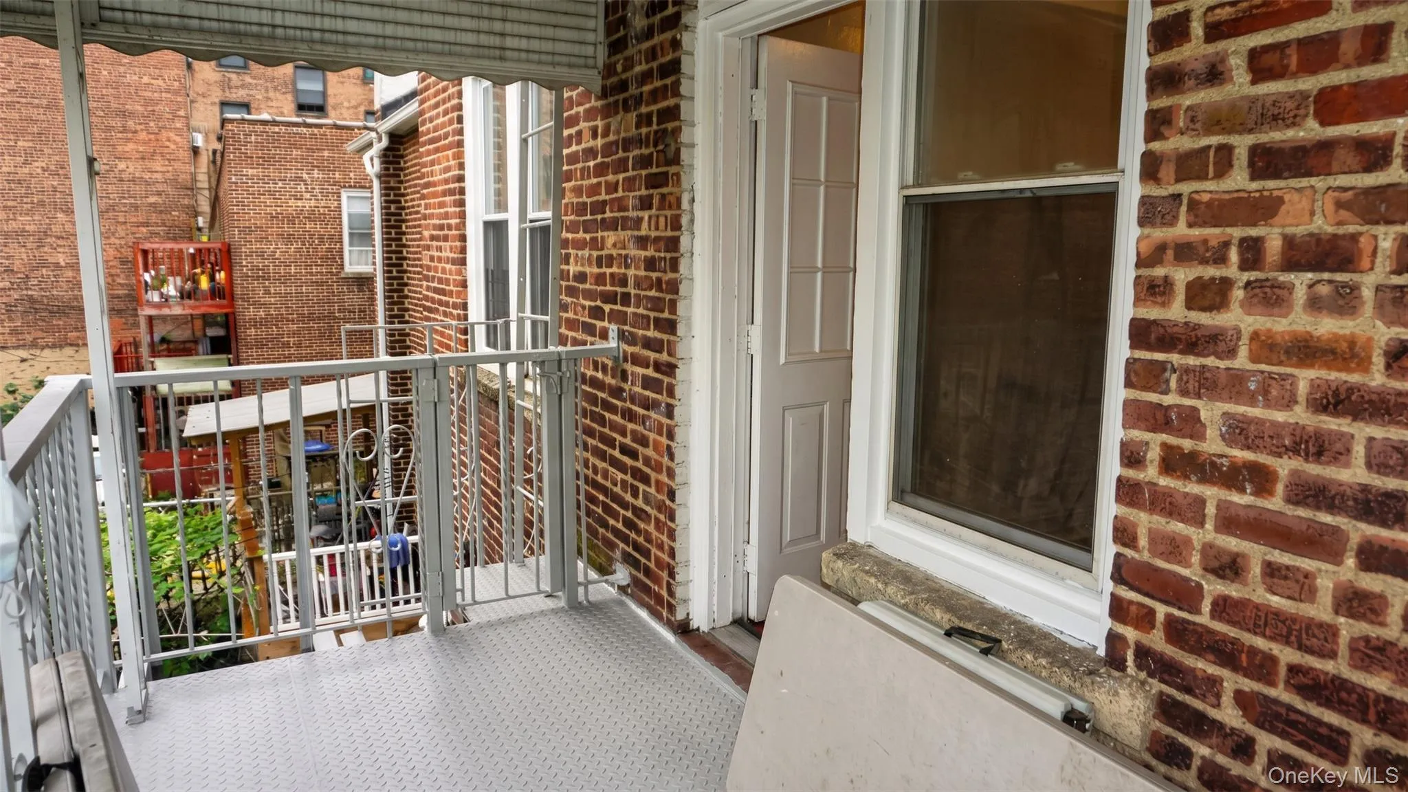 Balcony with metal railing, diamond plate flooring, and a corrugated metal awning Balcony with metal railing, diamond plate flooring, and a corrugated metal awning