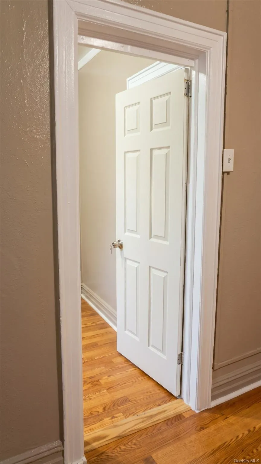 Hardwood flooring, classic window with trim, crown molding, baseboard molding, and a cast-iron radiator Hardwood flooring, classic window with trim, crown molding, baseboard molding, and a cast-iron radiator