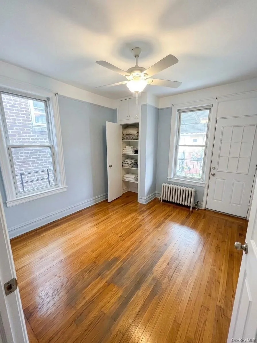 Hardwood flooring, built-in storage, ceiling fan, and two windows Hardwood flooring, built-in storage, ceiling fan, and two windows