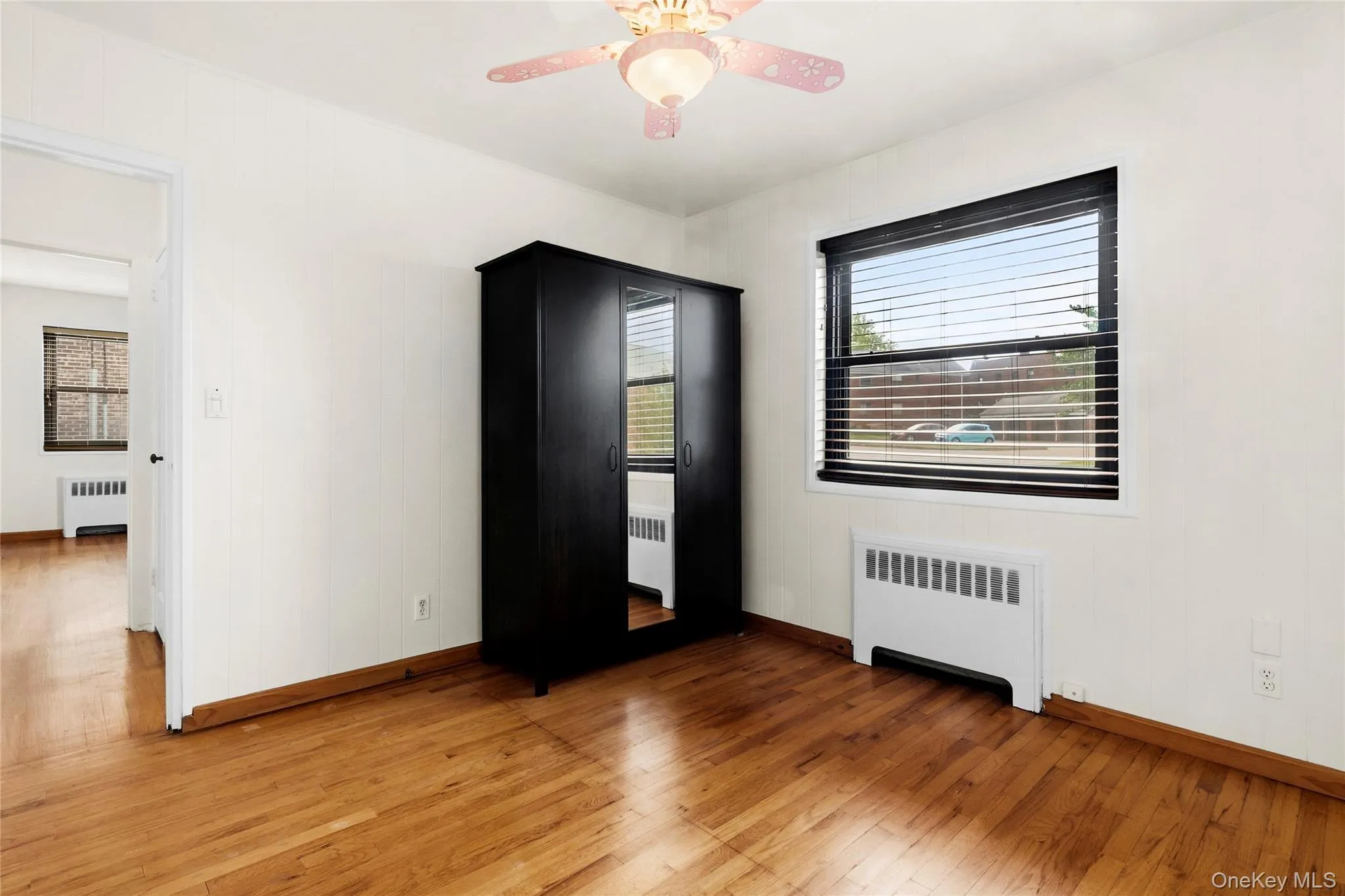 Hardwood flooring, painted white walls, ceiling fan, and window with blinds Hardwood flooring, painted white walls, ceiling fan, and window with blinds