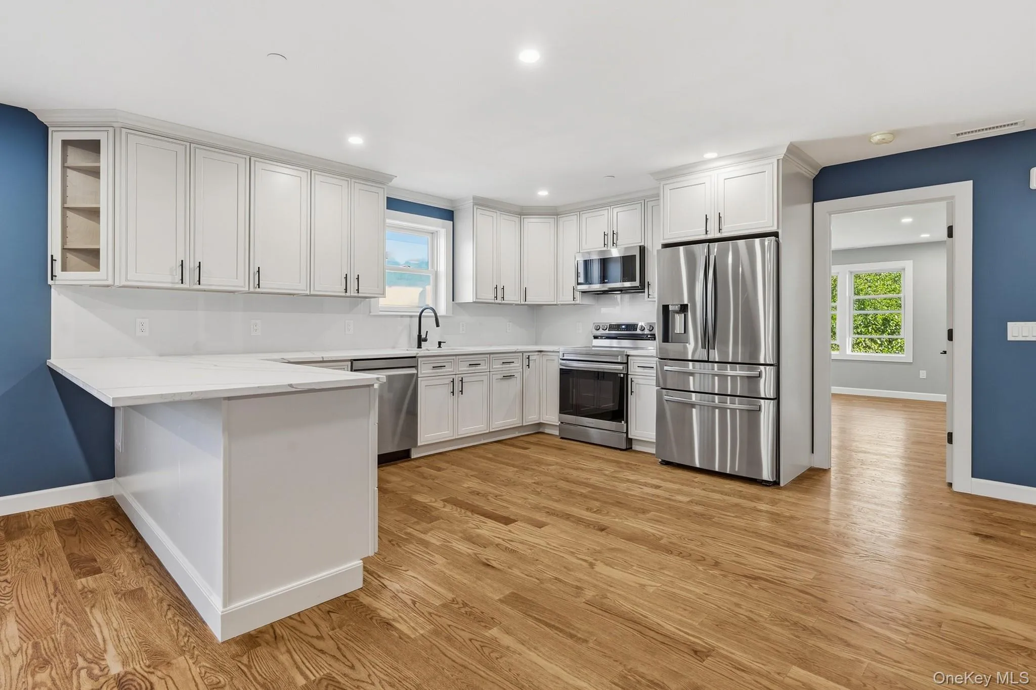 Modern large new kitchen with elegant cabinets, stainless steel appliances and wood floors Modern large new kitchen with elegant cabinets, stainless steel appliances and wood floors