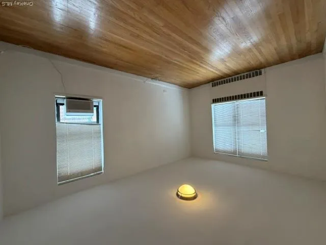 Hardwood flooring, window-mounted air conditioning unit, ceiling-mounted light fixture, and horizontal blinds Hardwood flooring, window-mounted air conditioning unit, ceiling-mounted light fixture, and horizontal blinds