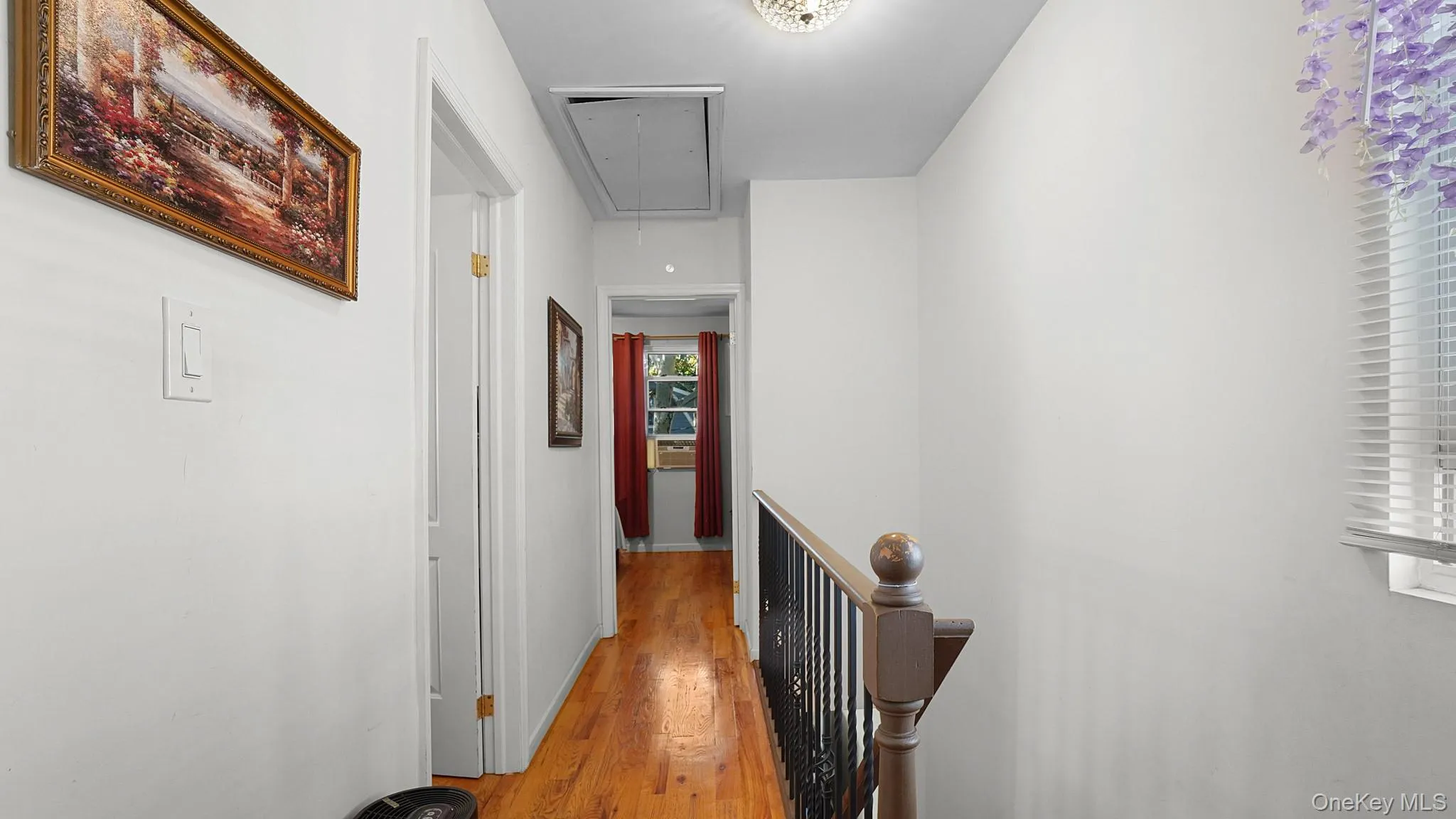 Wood-finish flooring throughout, white painted walls, and a window with blinds providing natural illumination Wood-finish flooring throughout, white painted walls, and a window with blinds providing natural illumination