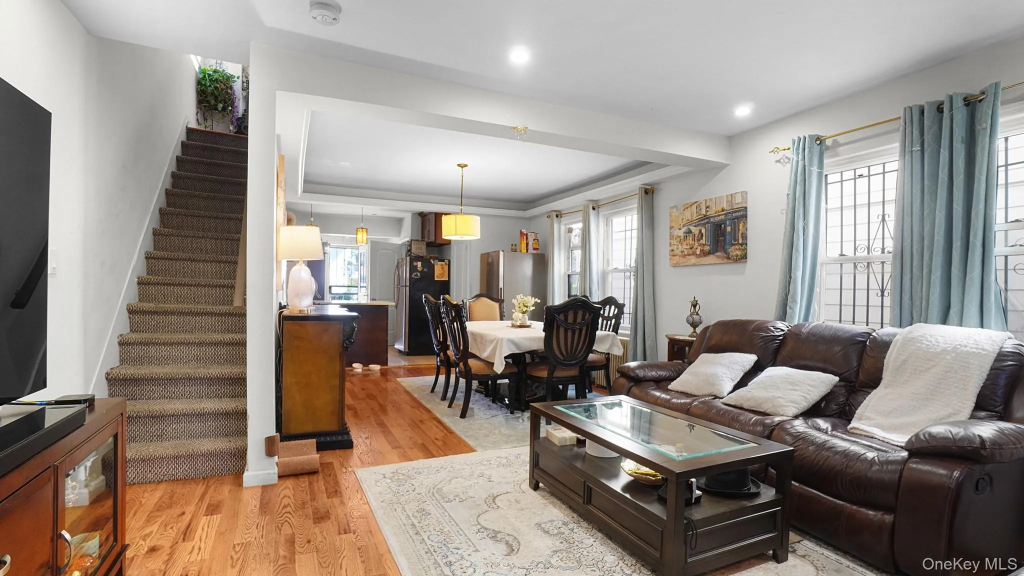 Hardwood flooring, recessed lighting, and a staircase with carpeted treads Hardwood flooring, recessed lighting, and a staircase with carpeted treads