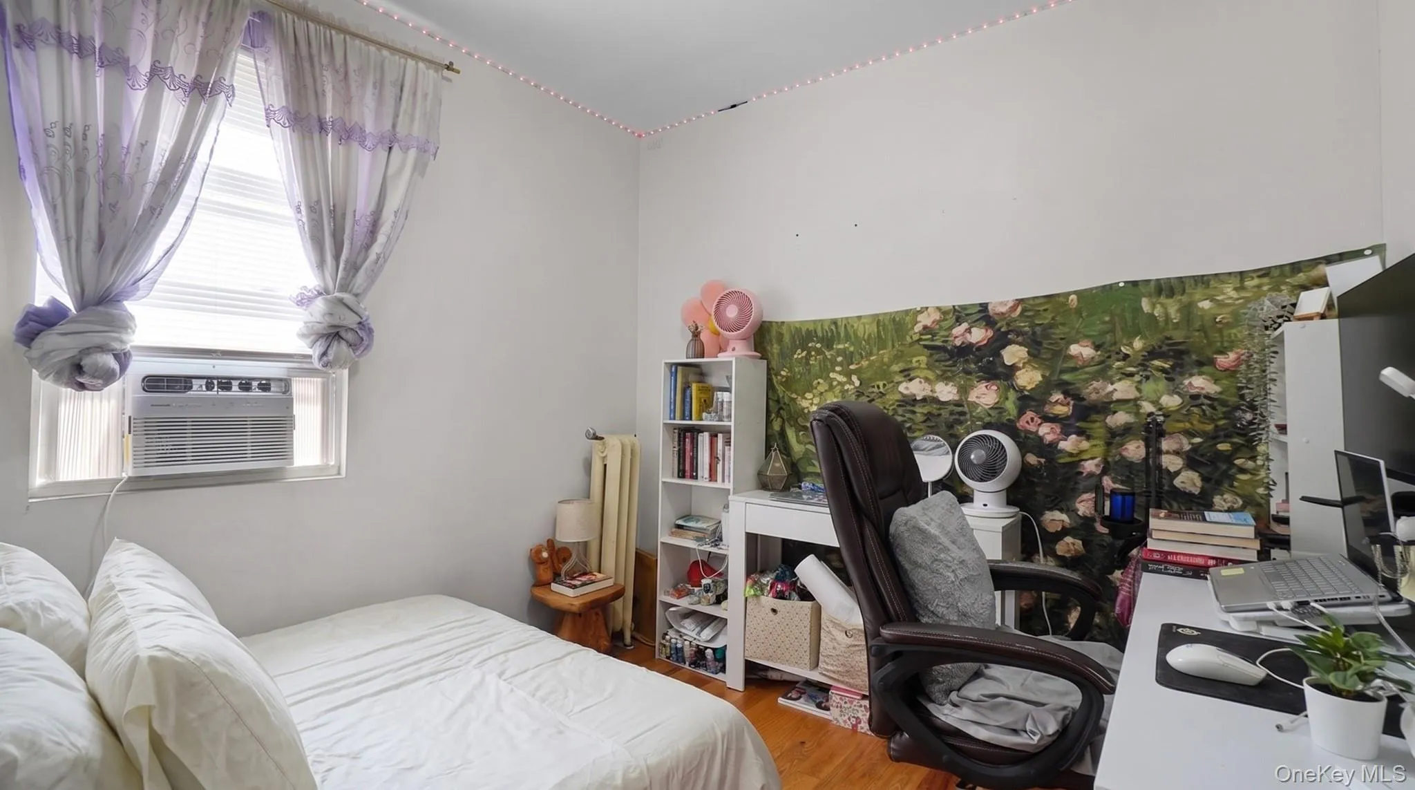 Hardwood-finish flooring, window-mounted air conditioning unit, and white painted walls Hardwood-finish flooring, window-mounted air conditioning unit, and white painted walls