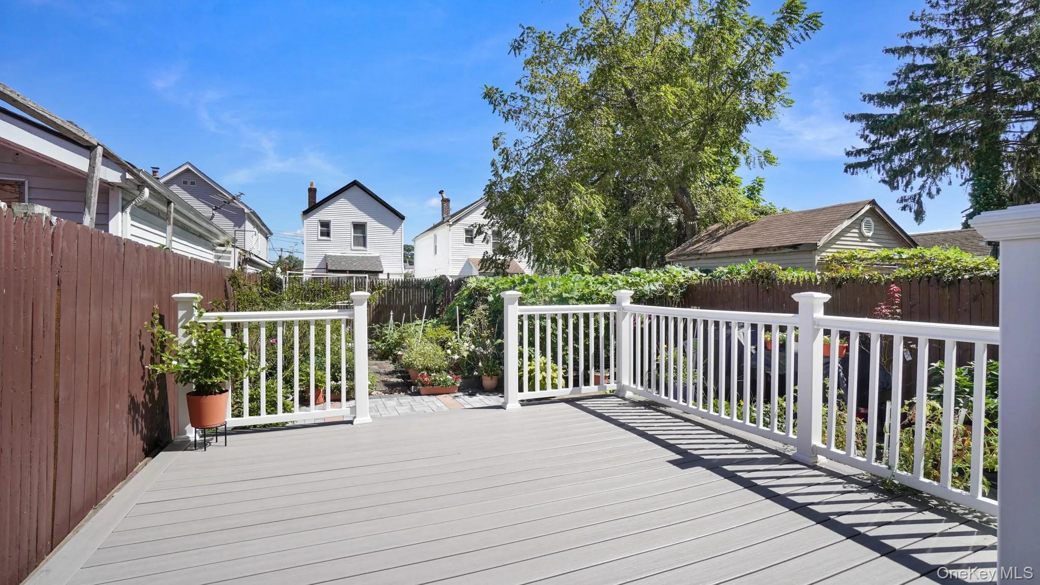 Spacious outdoor deck with composite decking and white railings Spacious outdoor deck with composite decking and white railings