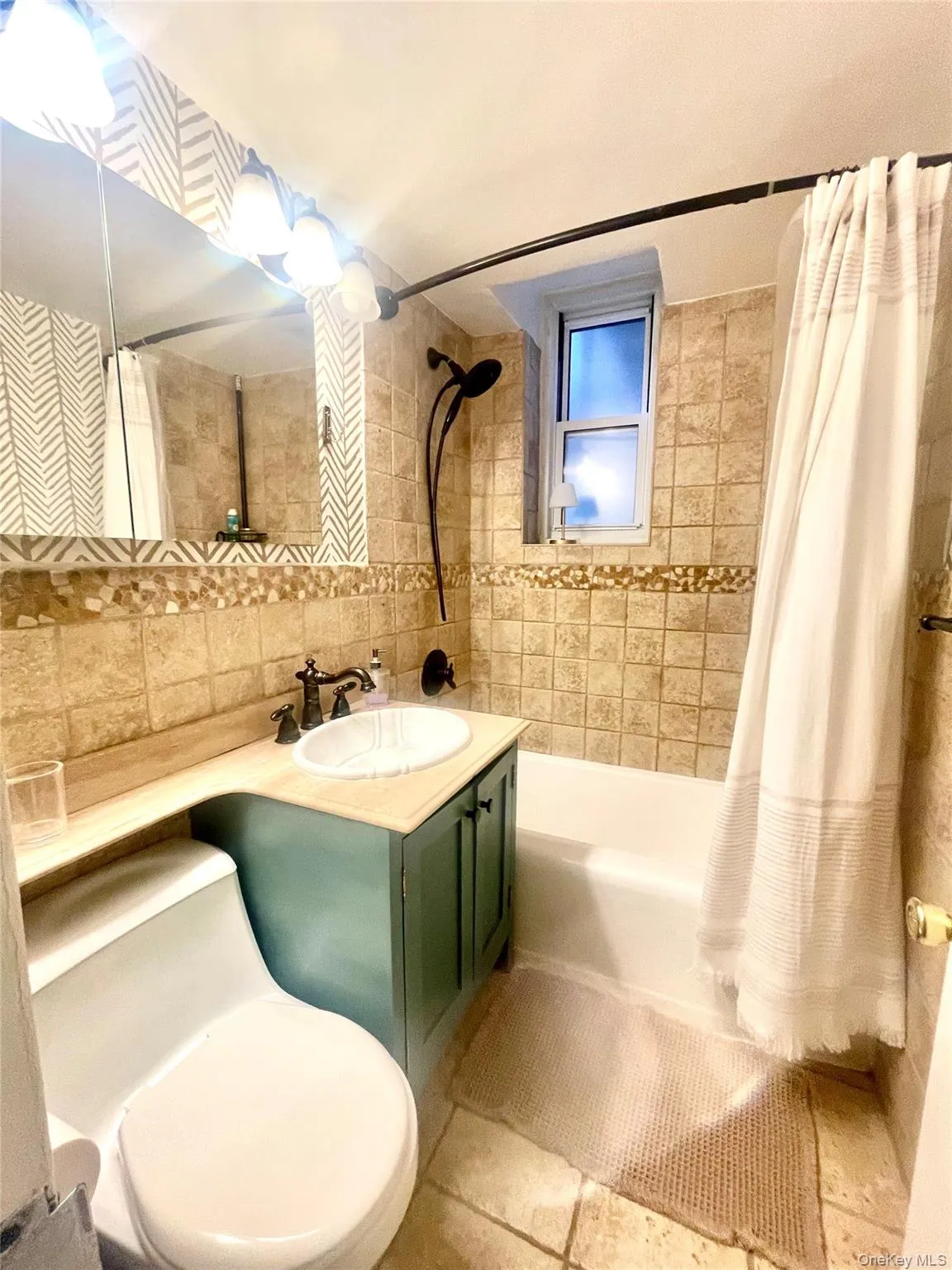 Bathroom featuring a built-in vanity with a circular basin, tiled walls, a window, a built-in bathtub, and a wall-mounted shower fixture Bathroom featuring a built-in vanity with a circular basin, tiled walls, a window, a built-in bathtub, and a wall-mounted shower fixture
