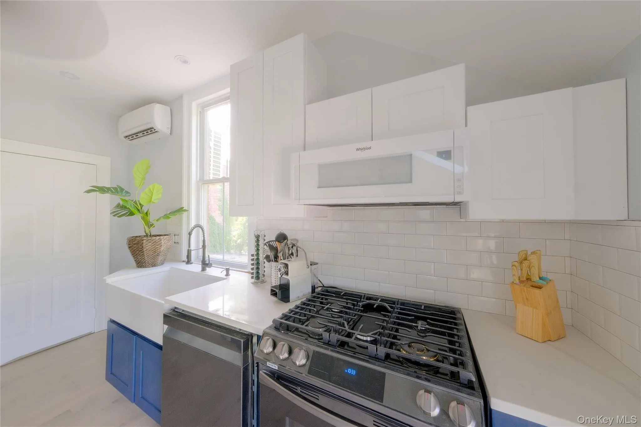 White shaker cabinetry, quartz countertops, tile backsplash, stainless steel appliances, and a farmhouse sink White shaker cabinetry, quartz countertops, tile backsplash, stainless steel appliances, and a farmhouse sink