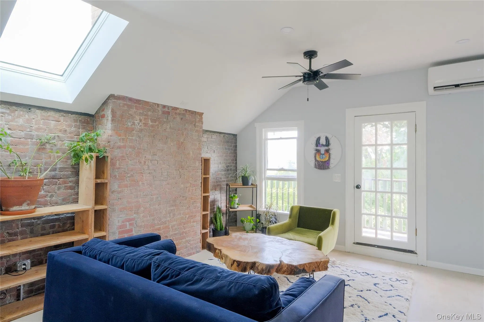 Vaulted ceilings, exposed brick accent walls, a skylight, and wood-finish flooring Vaulted ceilings, exposed brick accent walls, a skylight, and wood-finish flooring