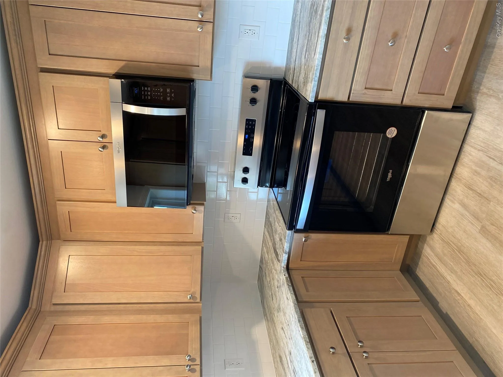 Kitchen featuring appliances with stainless steel finishes, light stone countertops, tasteful backsplash, and light wood finished floors Kitchen featuring appliances with stainless steel finishes, light stone countertops, tasteful backsplash, and light wood finished floors