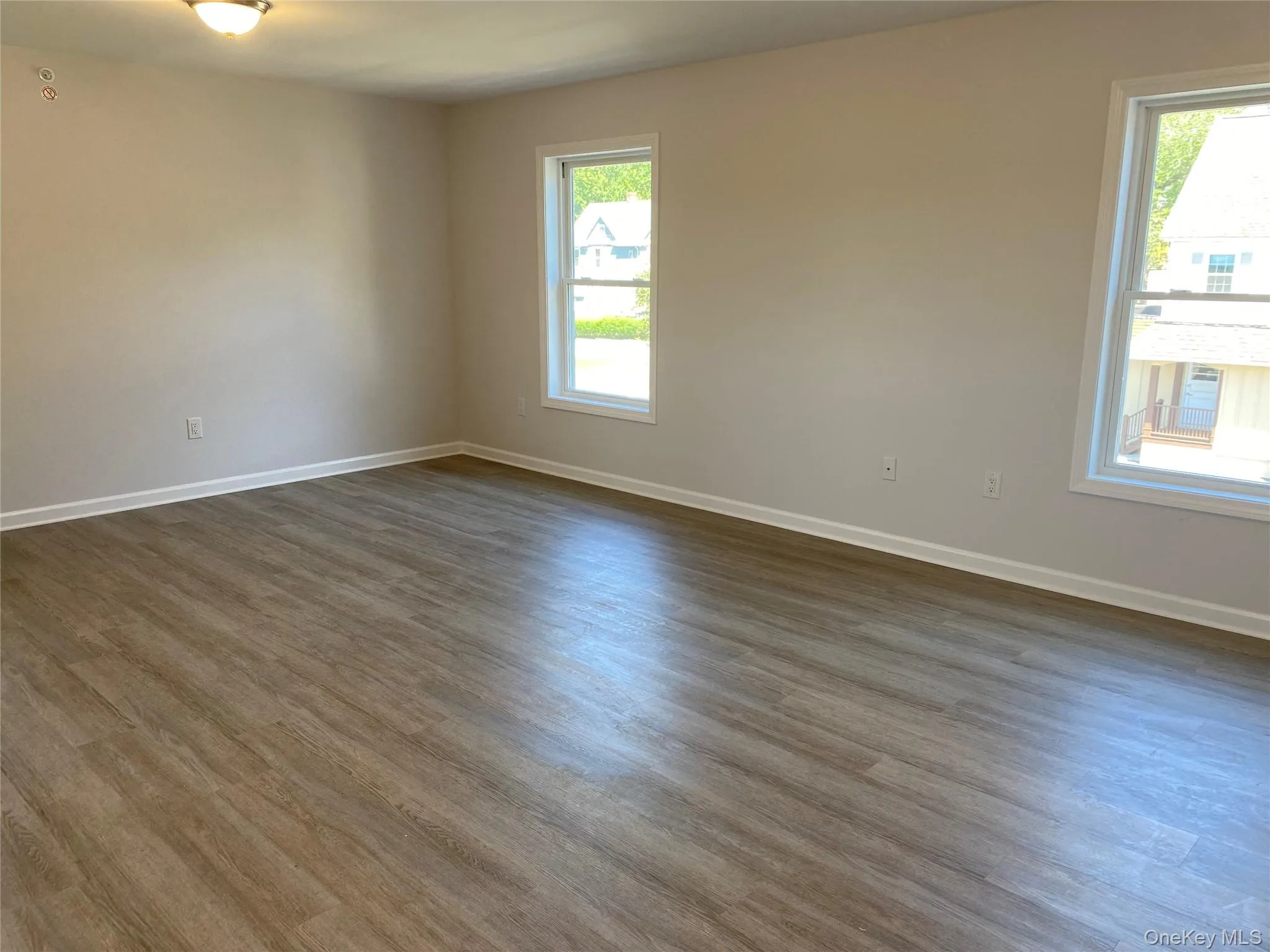 Spare room featuring dark wood-style flooring Spare room featuring dark wood-style flooring