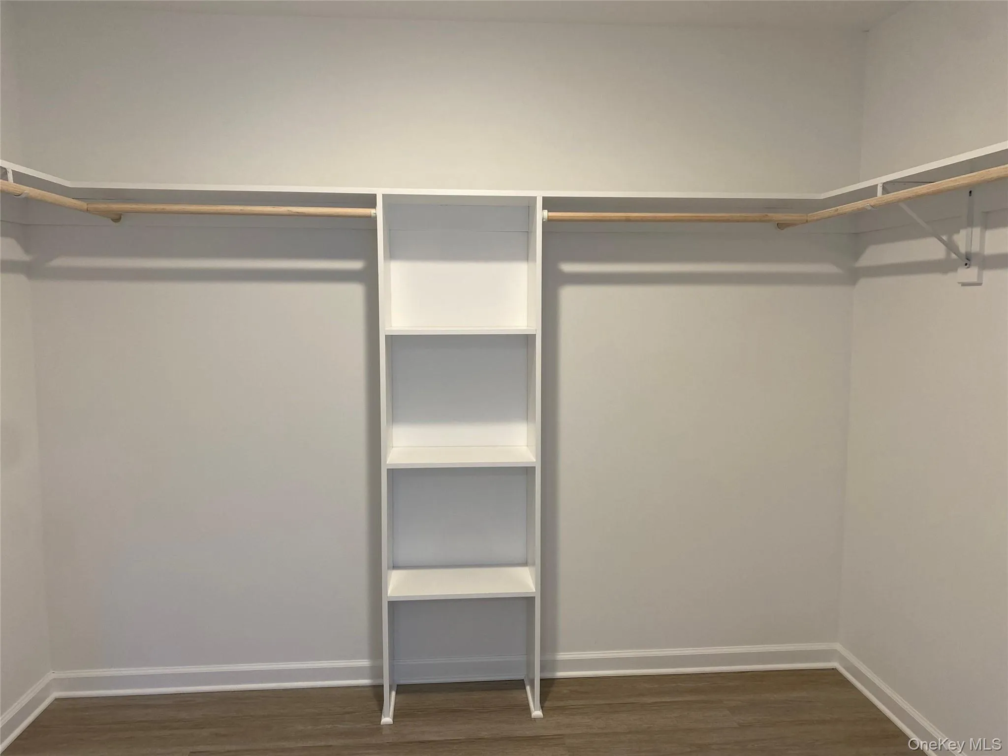 Spacious closet with dark wood-type flooring Spacious closet with dark wood-type flooring