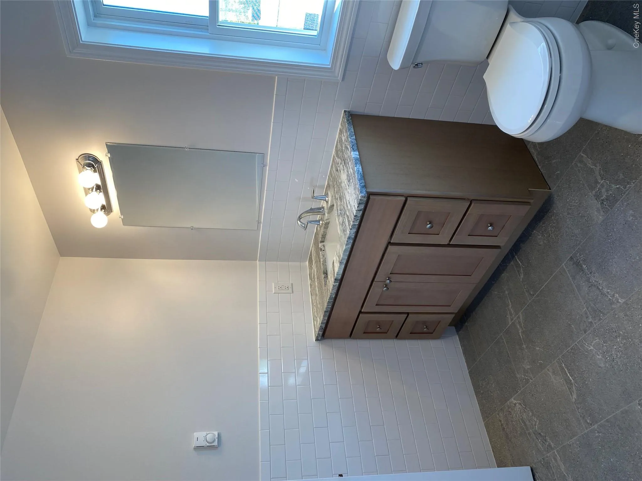 Bathroom with tile walls, wainscoting, and vanity Bathroom with tile walls, wainscoting, and vanity