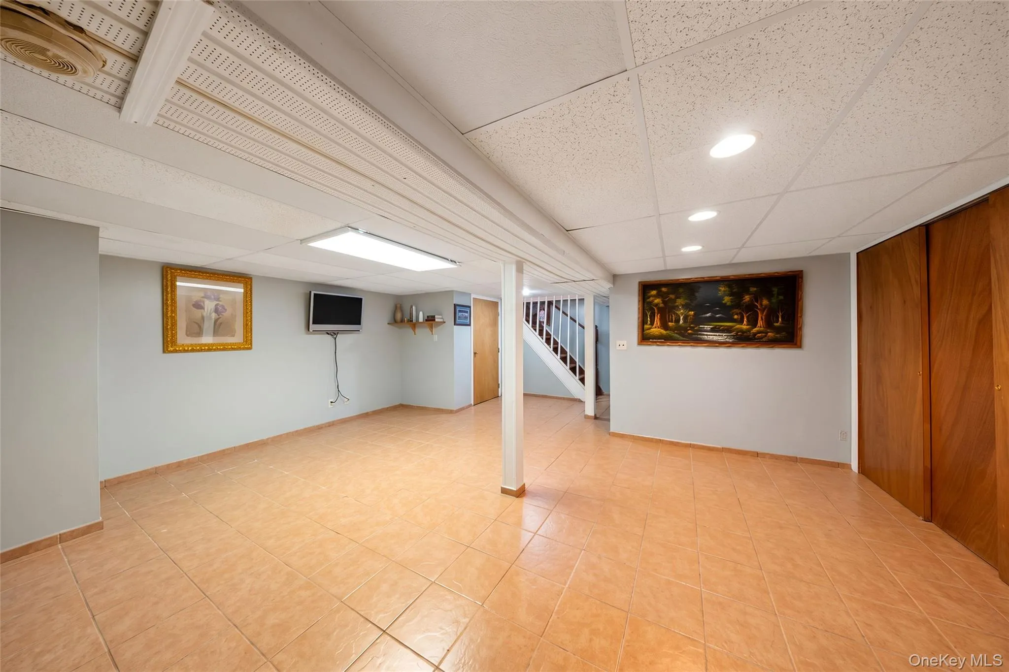 Recessed lighting, tile flooring, wood paneling, wood staircase, and a drop ceiling Recessed lighting, tile flooring, wood paneling, wood staircase, and a drop ceiling