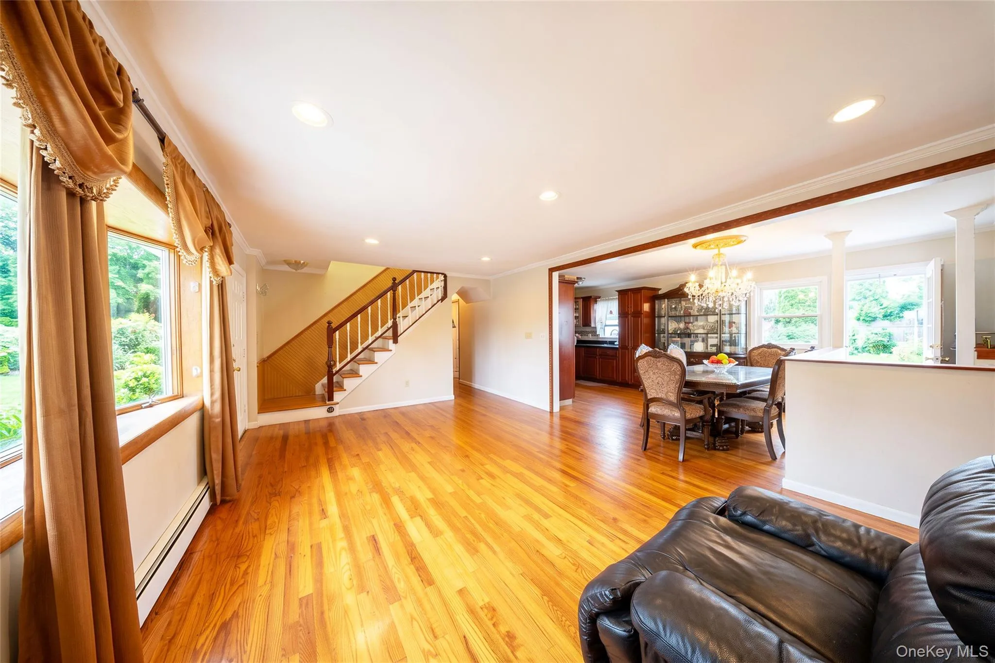 Hardwood flooring throughout, recessed lighting, and a staircase with wood handrails Hardwood flooring throughout, recessed lighting, and a staircase with wood handrails