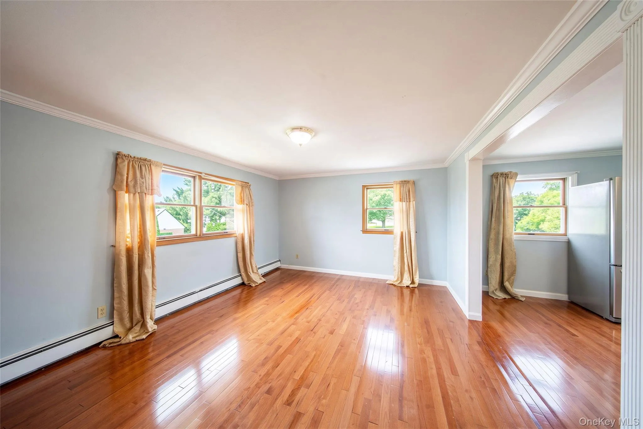 Hardwood flooring, crown molding, multiple windows, and a semi-open architectural feature Hardwood flooring, crown molding, multiple windows, and a semi-open architectural feature