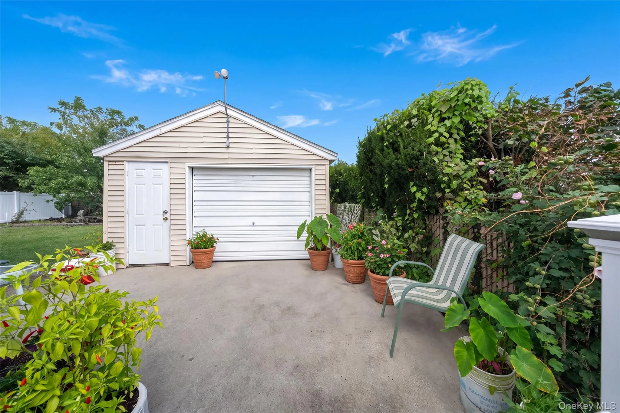 Detached garage with horizontal siding, a roll-up door, and a side entry door Detached garage with horizontal siding, a roll-up door, and a side entry door