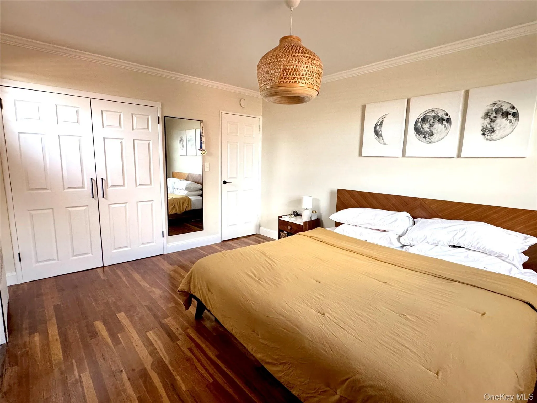 Wood-finish flooring, white paneled closet doors, and a chandelier Wood-finish flooring, white paneled closet doors, and a chandelier