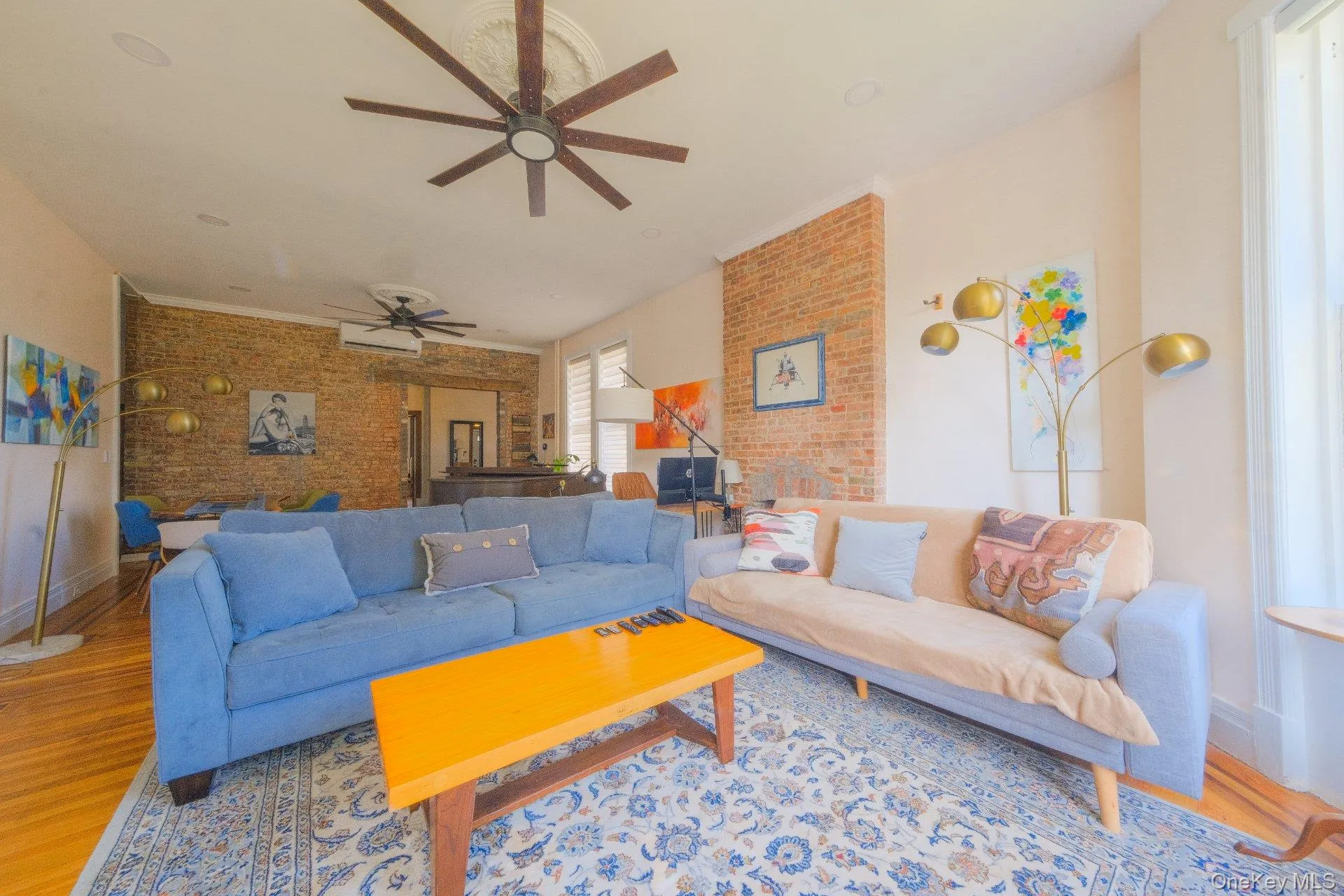 Exposed brick wall, natural wood-finish flooring, recessed lighting, and ceiling fans Exposed brick wall, natural wood-finish flooring, recessed lighting, and ceiling fans