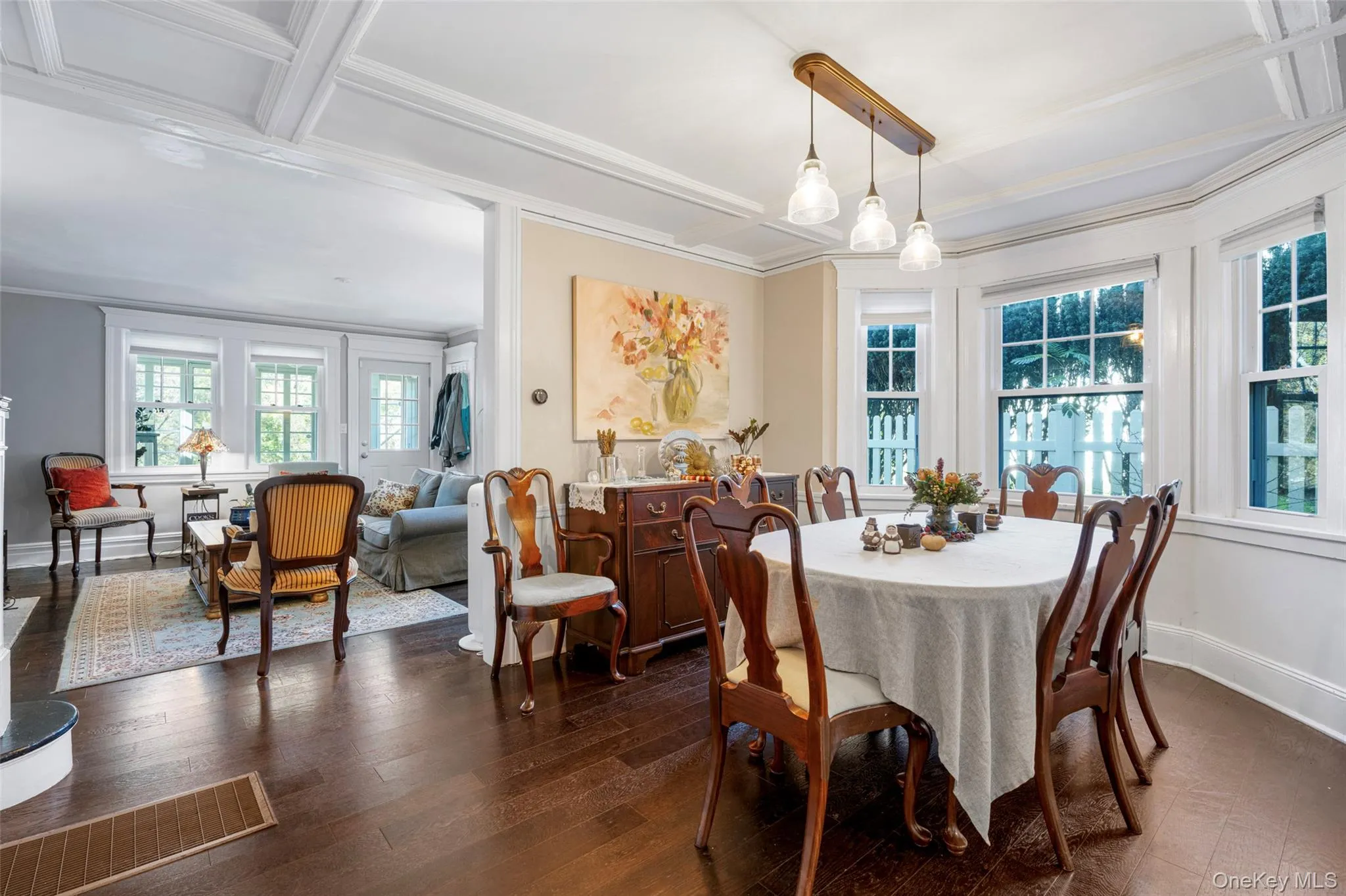 Dining room featuring dark wood-type flooring, a wealth of natural light, and ornamental molding Dining room featuring dark wood-type flooring, a wealth of natural light, and ornamental molding