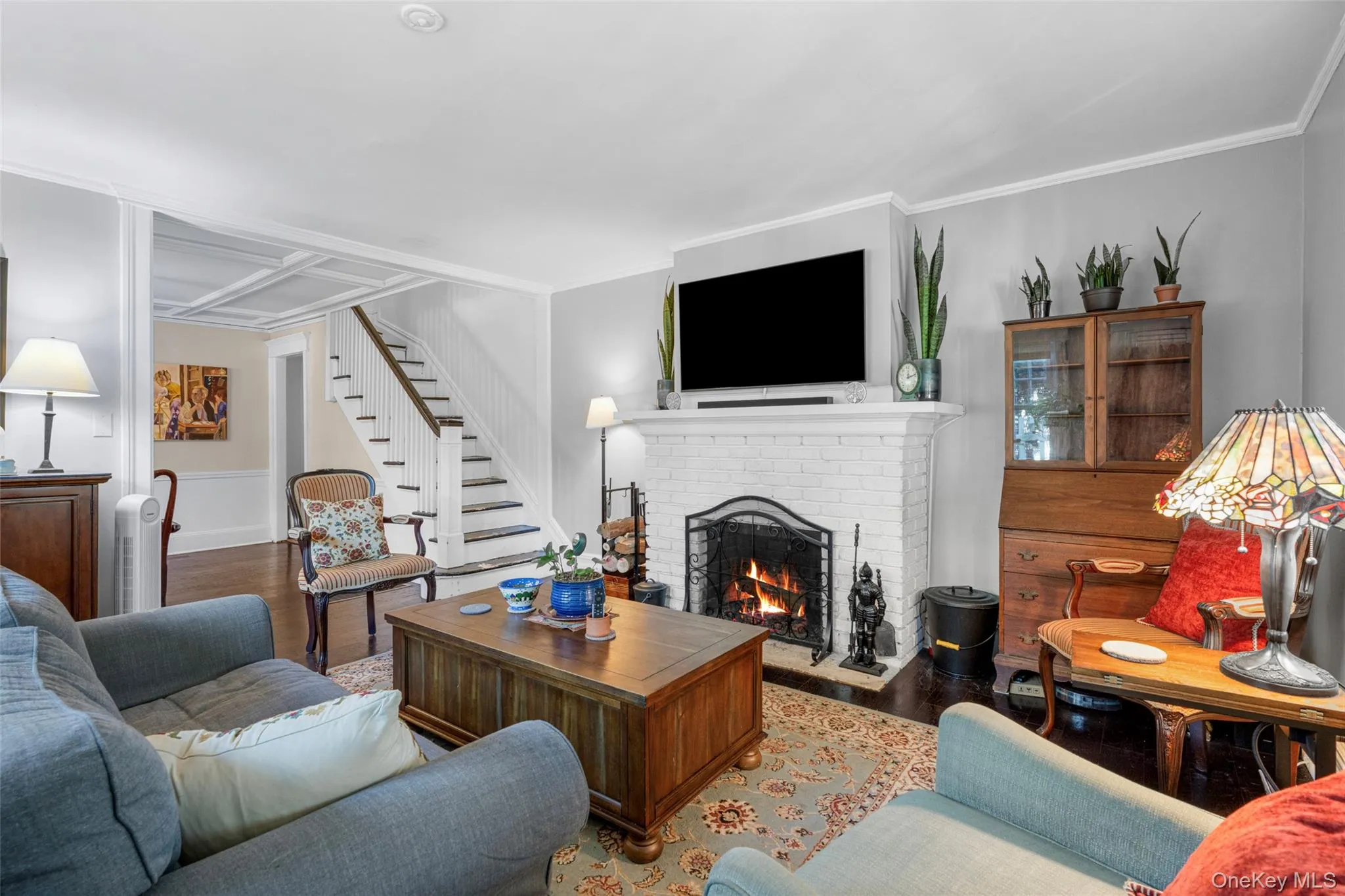 Living room with ornamental molding, hardwood / wood-style floors, and a fireplace Living room with ornamental molding, hardwood / wood-style floors, and a fireplace